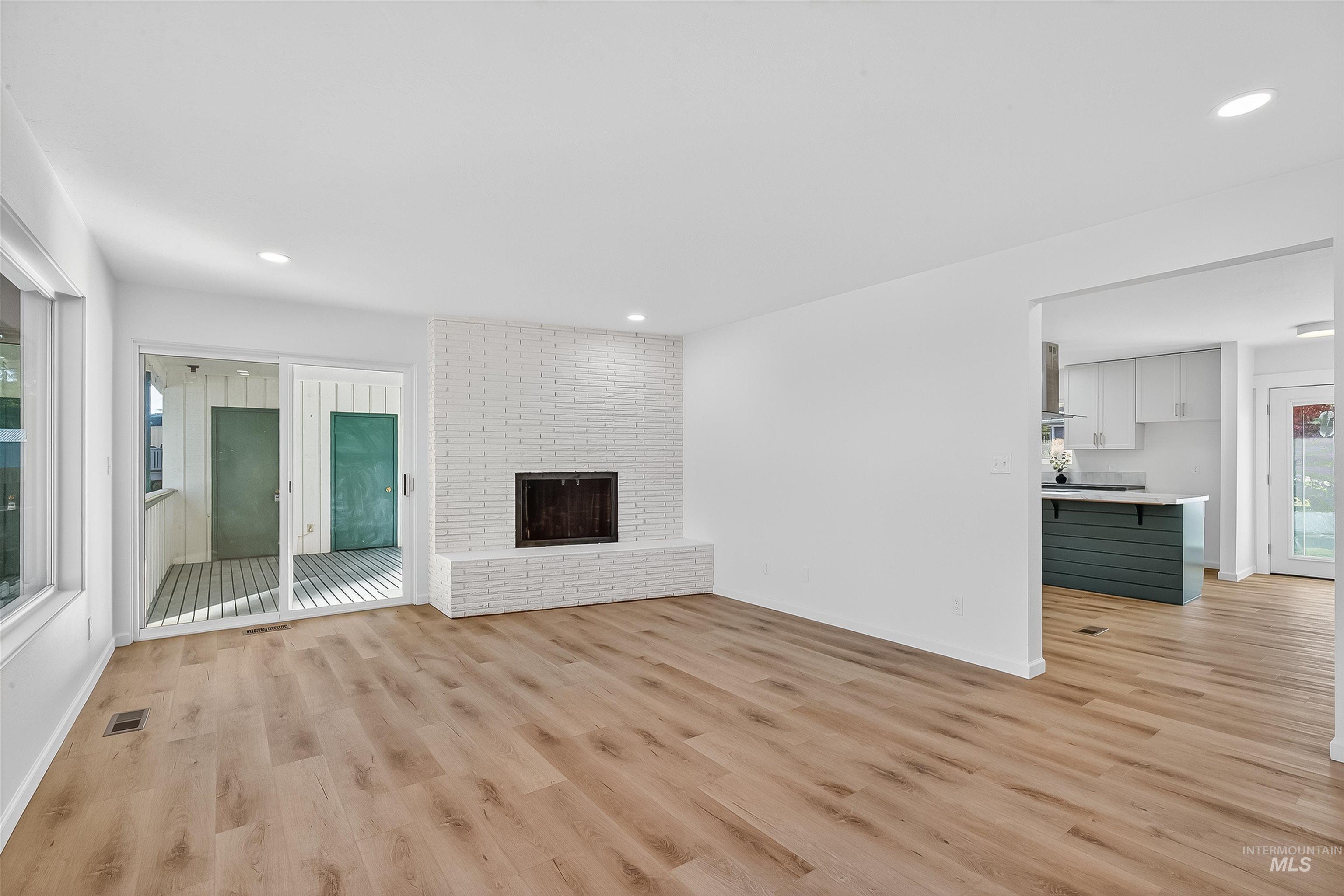 Unfurnished living room with light wood-style floors, a fireplace, and recessed lighting