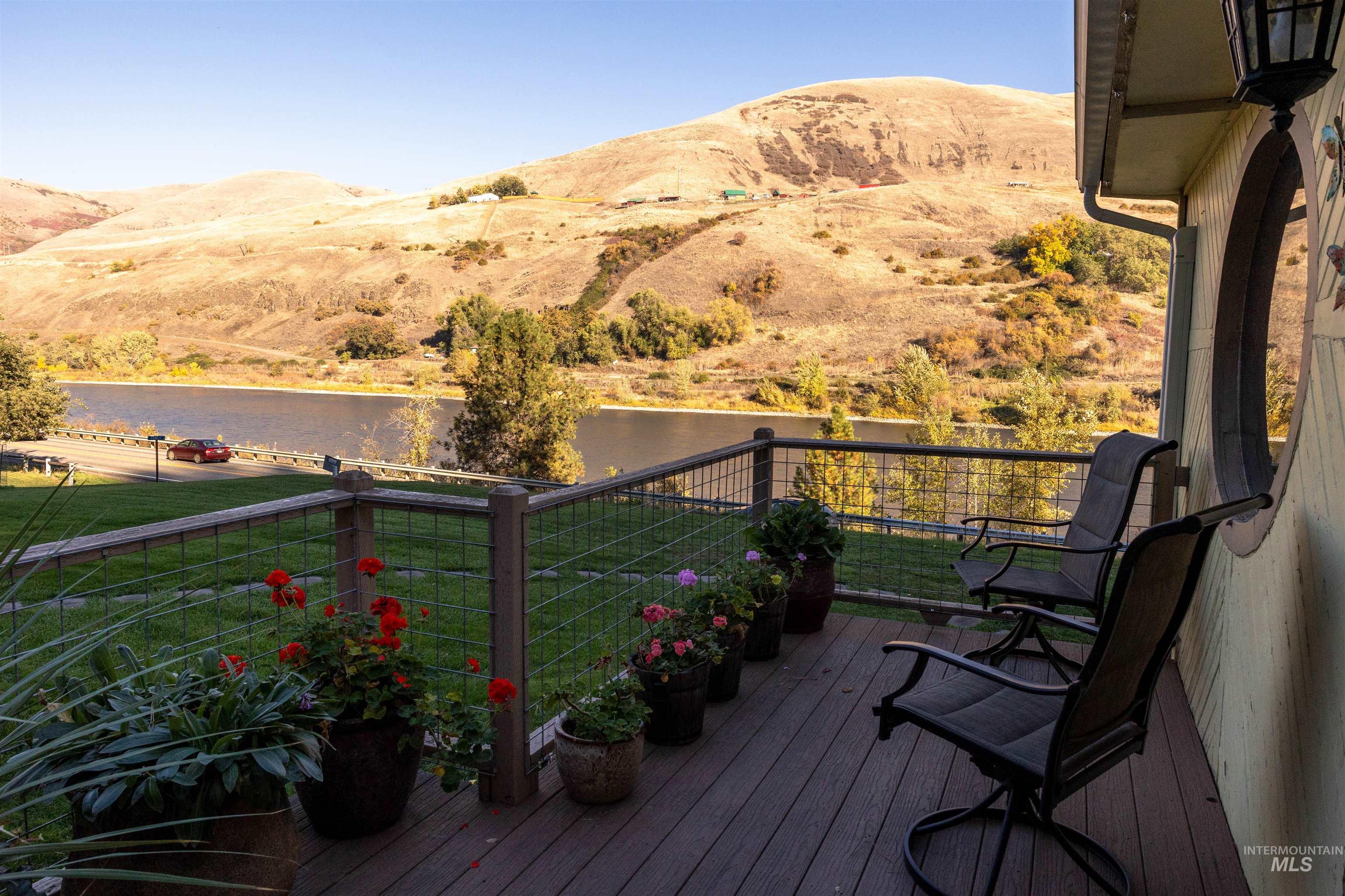 Wooden deck with a water and mountain view and a yard