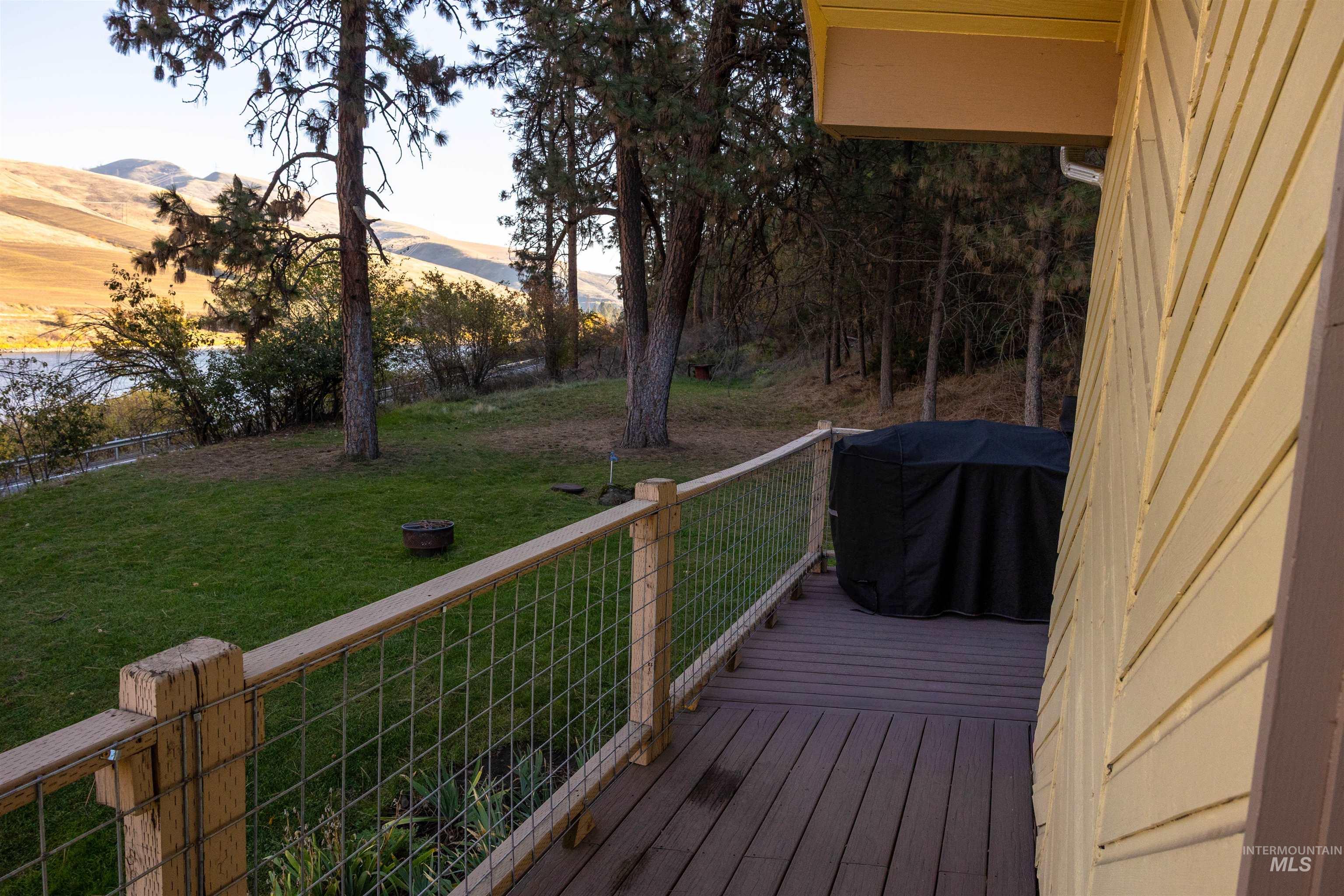 Wooden deck with a yard, grilling area, and a mountain view