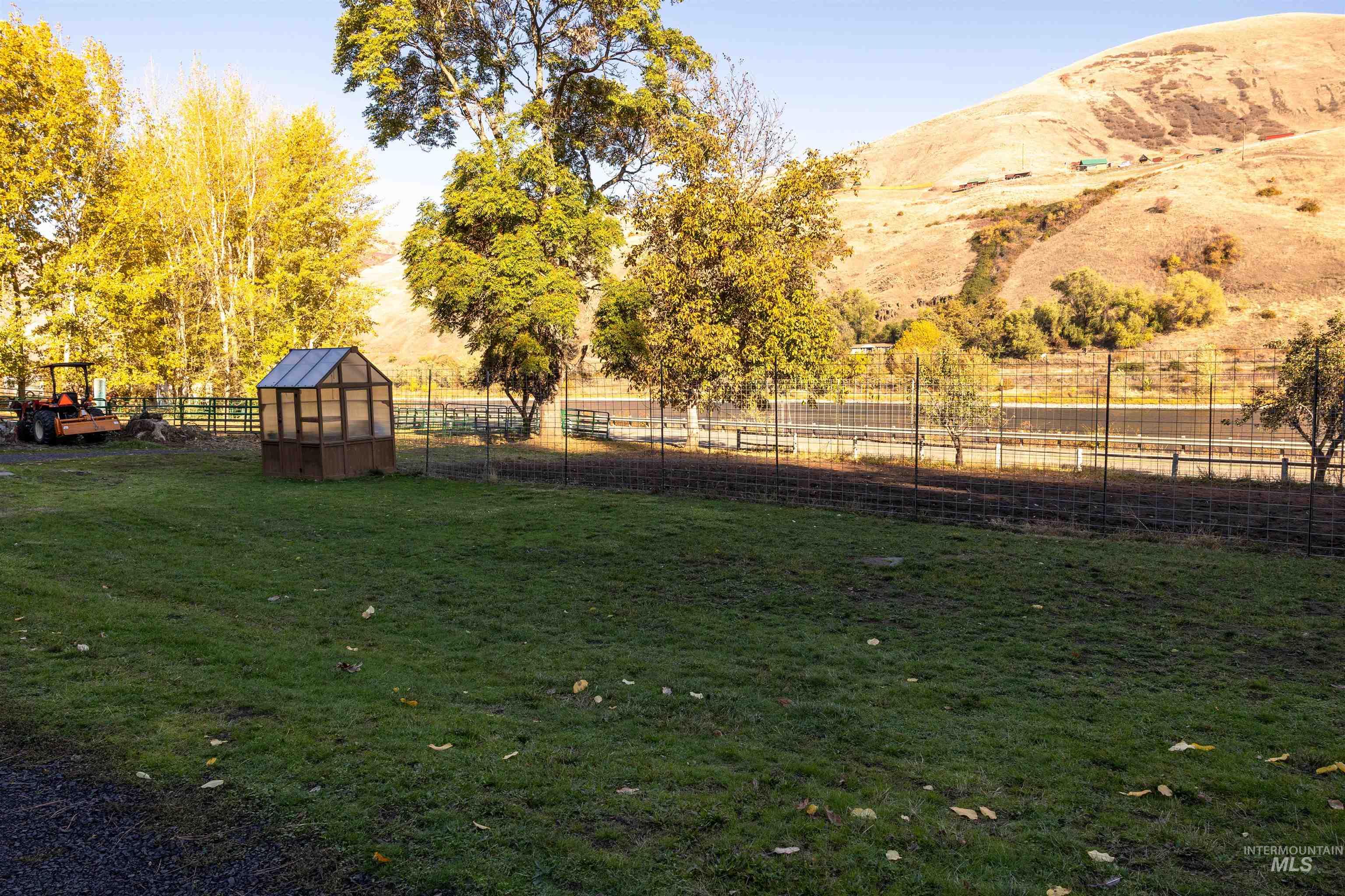 View of yard with an outdoor structure, an exterior structure, a mountain view, and a view of rural / pastoral area