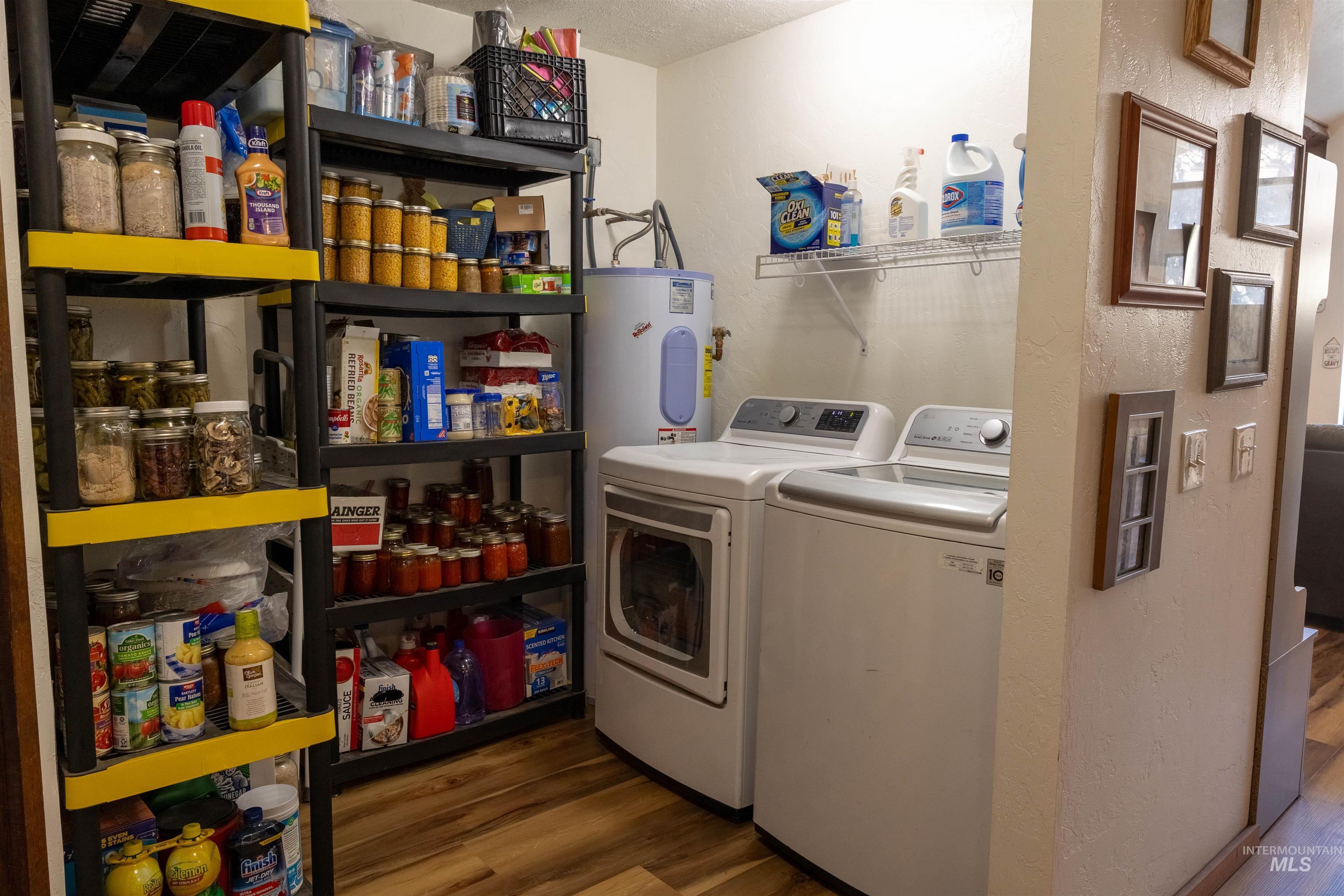 Laundry area featuring dark wood-style floors, separate washer and dryer, a textured wall, a textured ceiling, and electric water heater