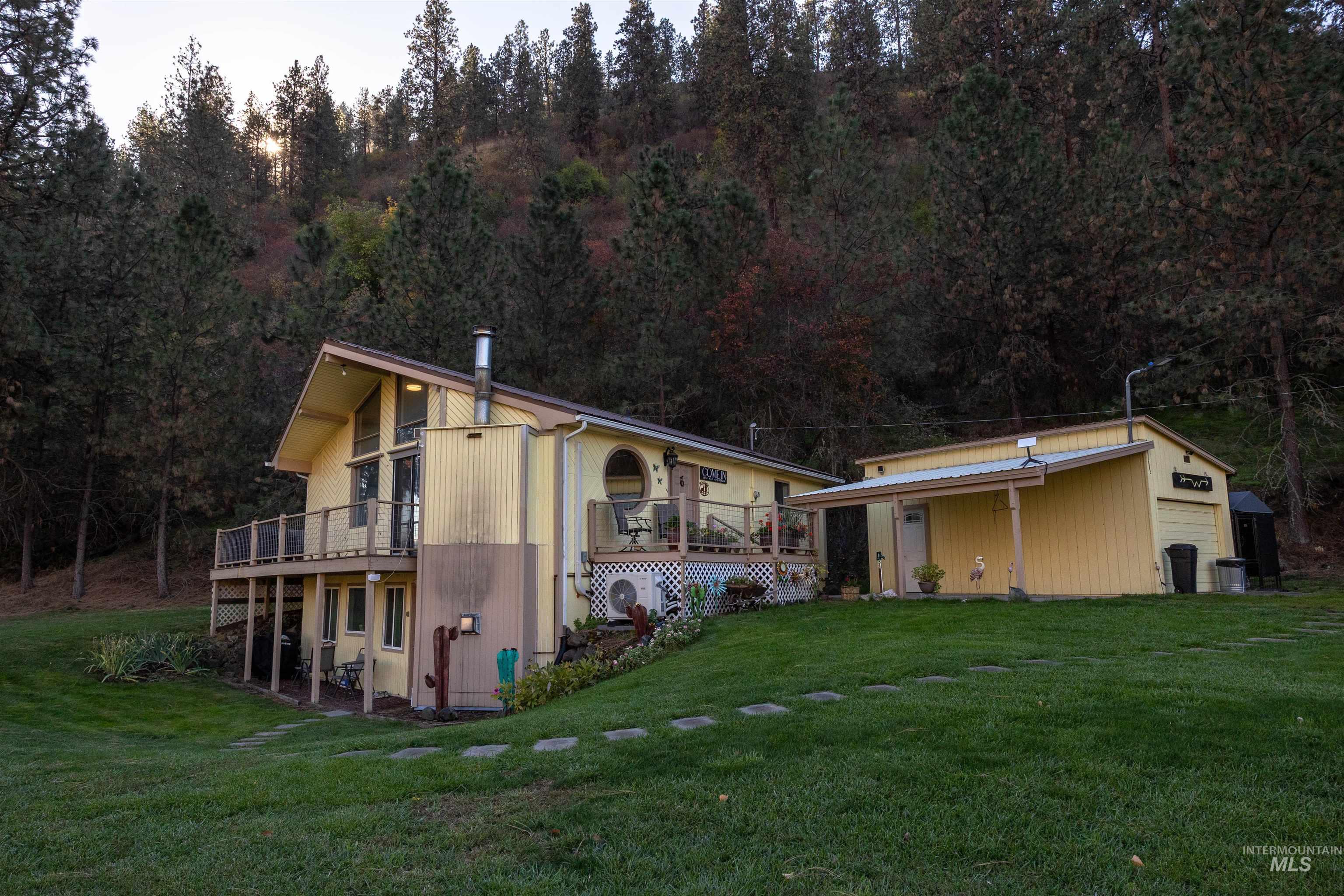Back of house with a lawn, a wooden deck, and a patio