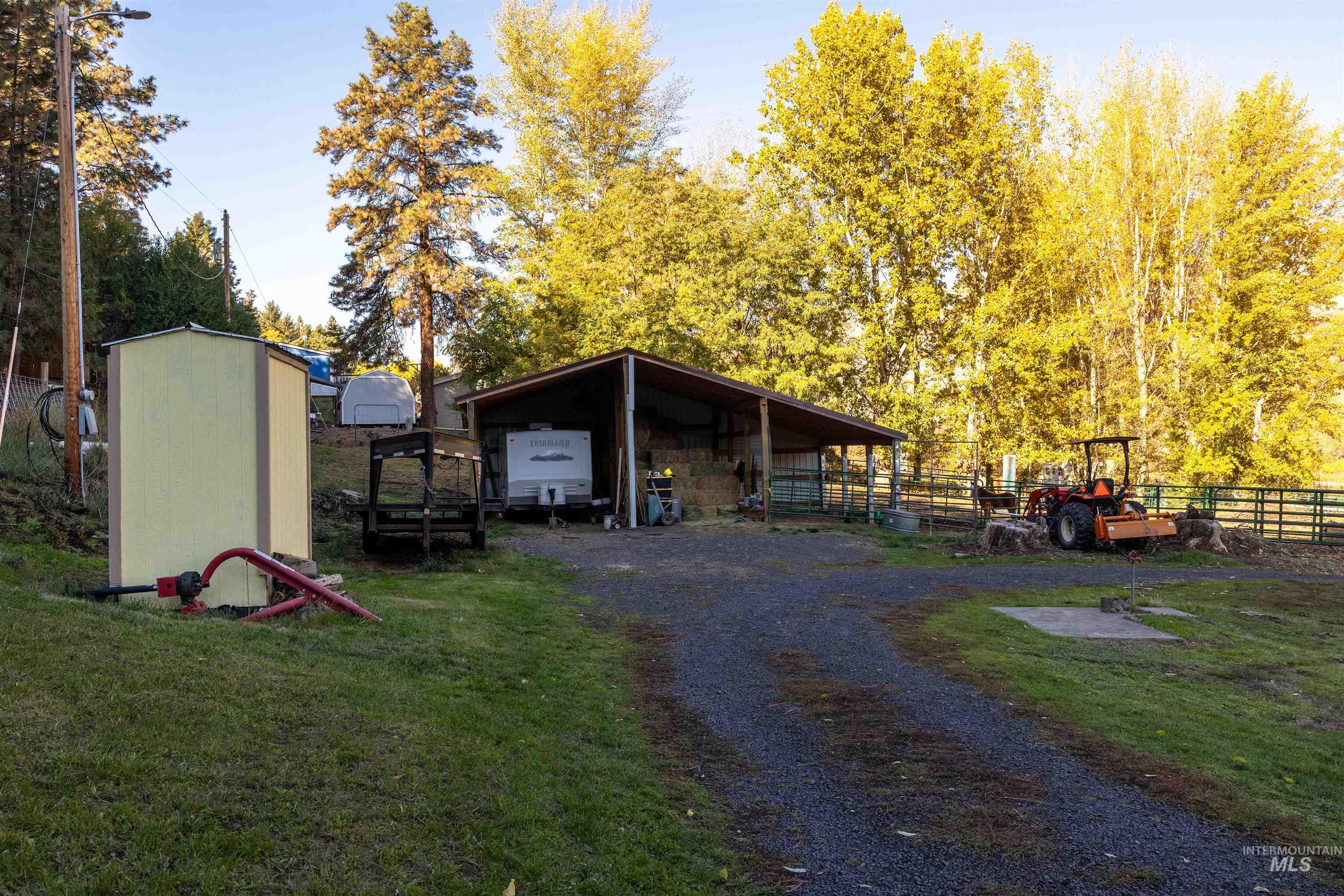 View of outbuilding with a carport and gravel driveway