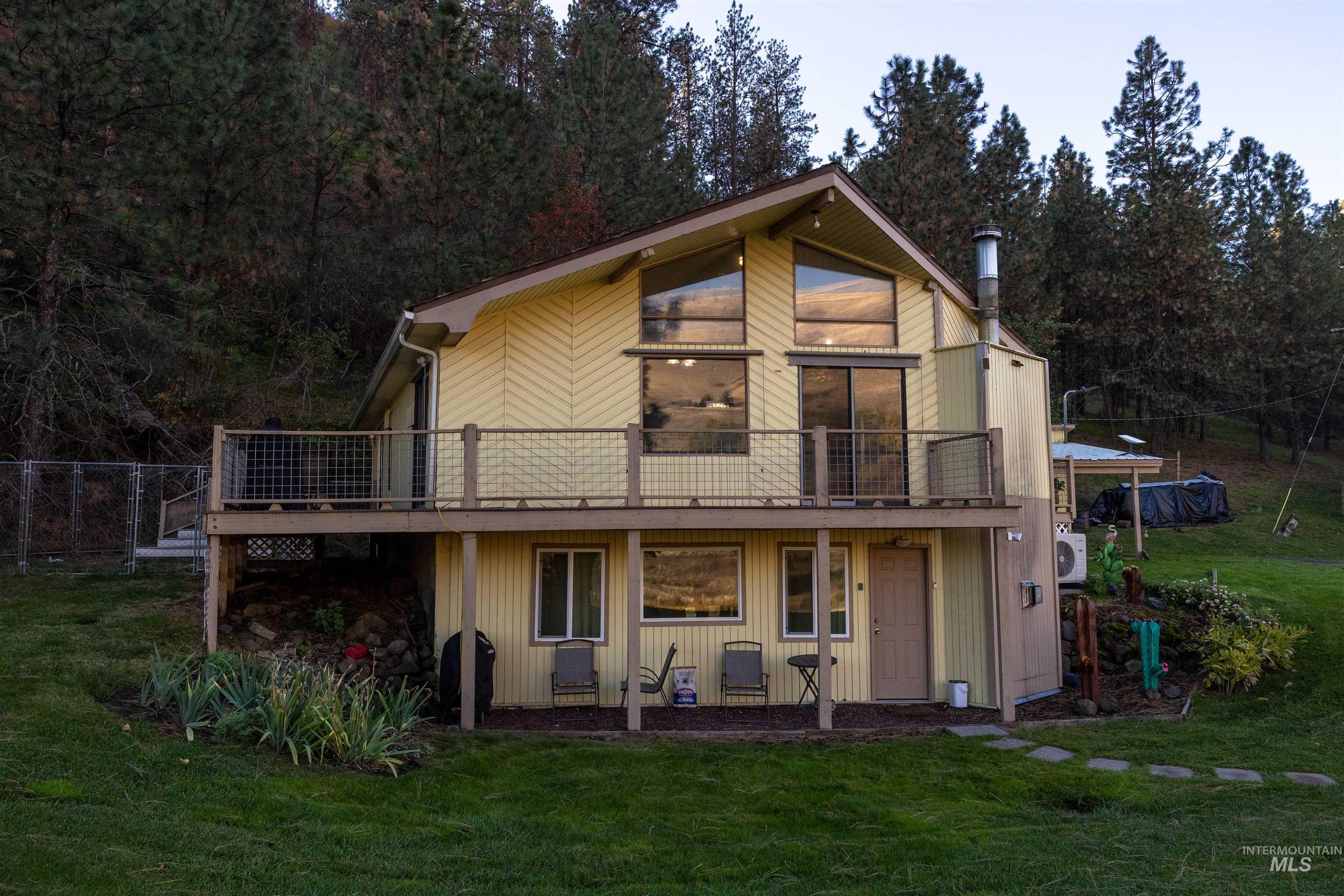 Back of house featuring a lawn and a deck