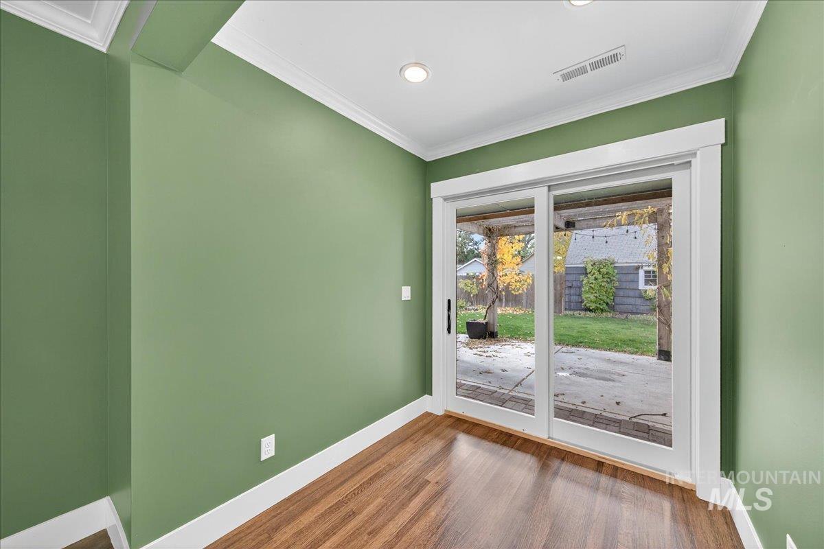 Doorway to outside with crown molding, wood finished floors, and recessed lighting