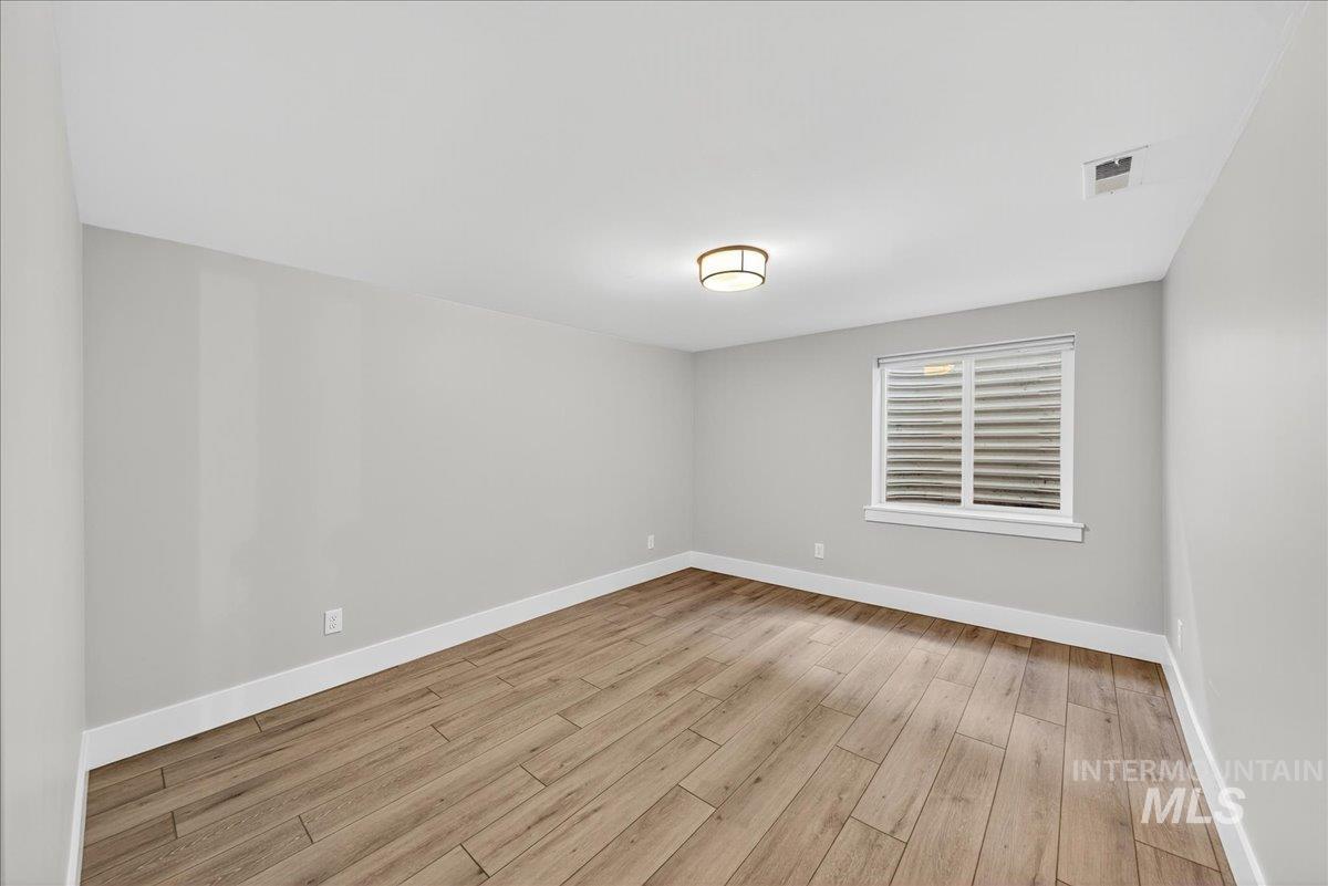 Unfurnished room with baseboards and light wood-style floors