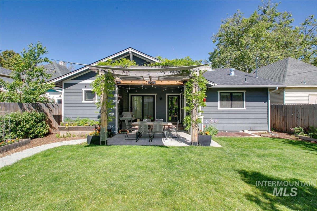 Back of property with a fenced backyard, a patio area, and a vegetable garden