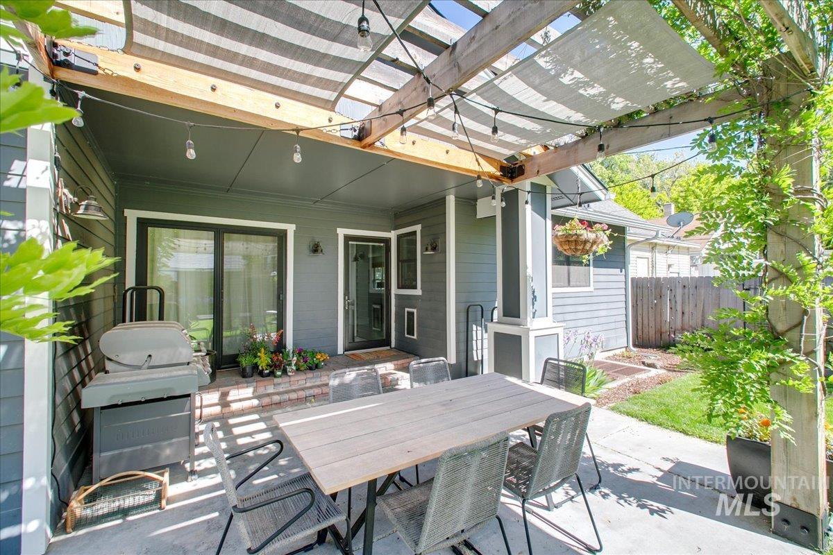 View of patio with outdoor dining space, a grill, and a pergola