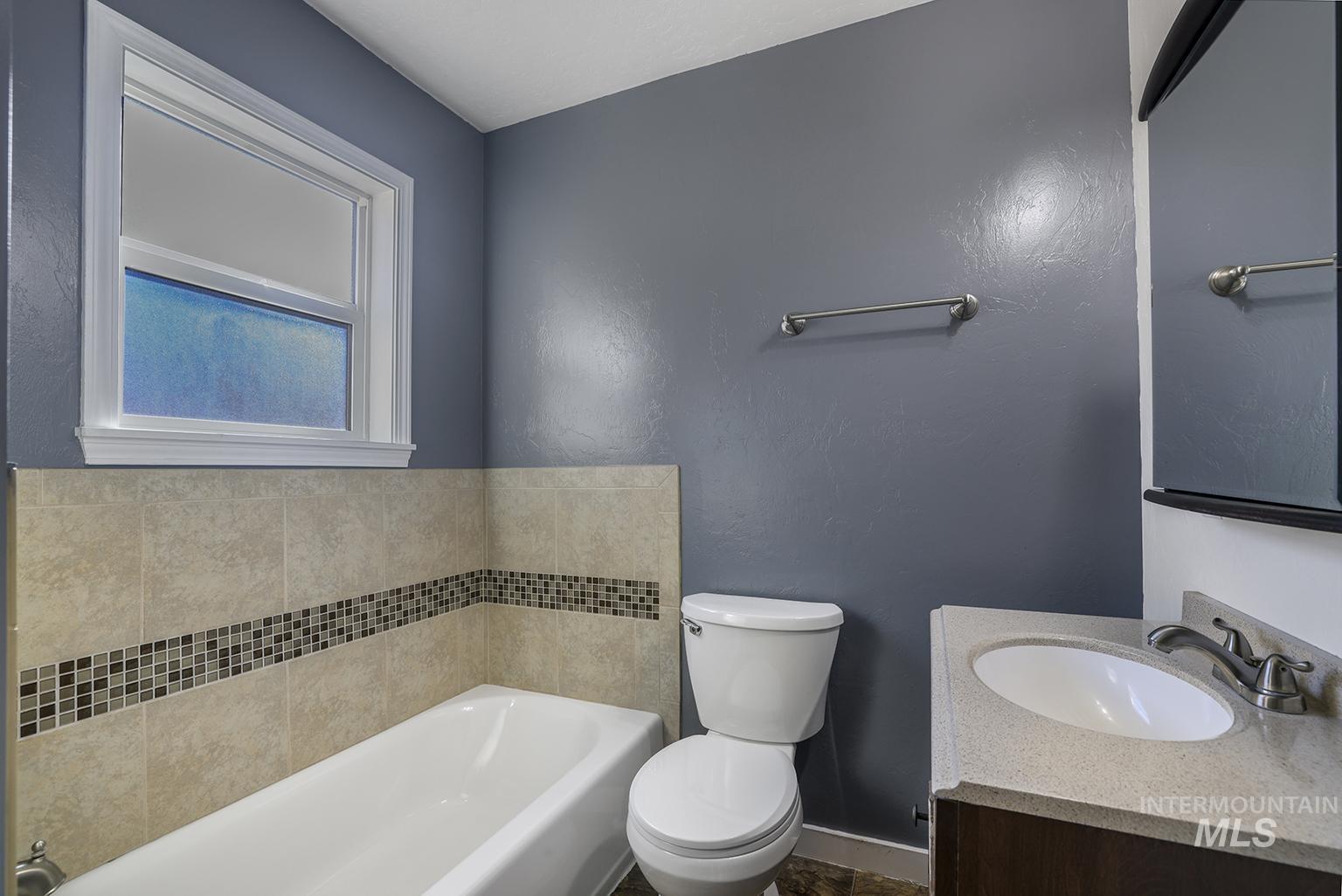 Bathroom featuring a garden tub and vanity