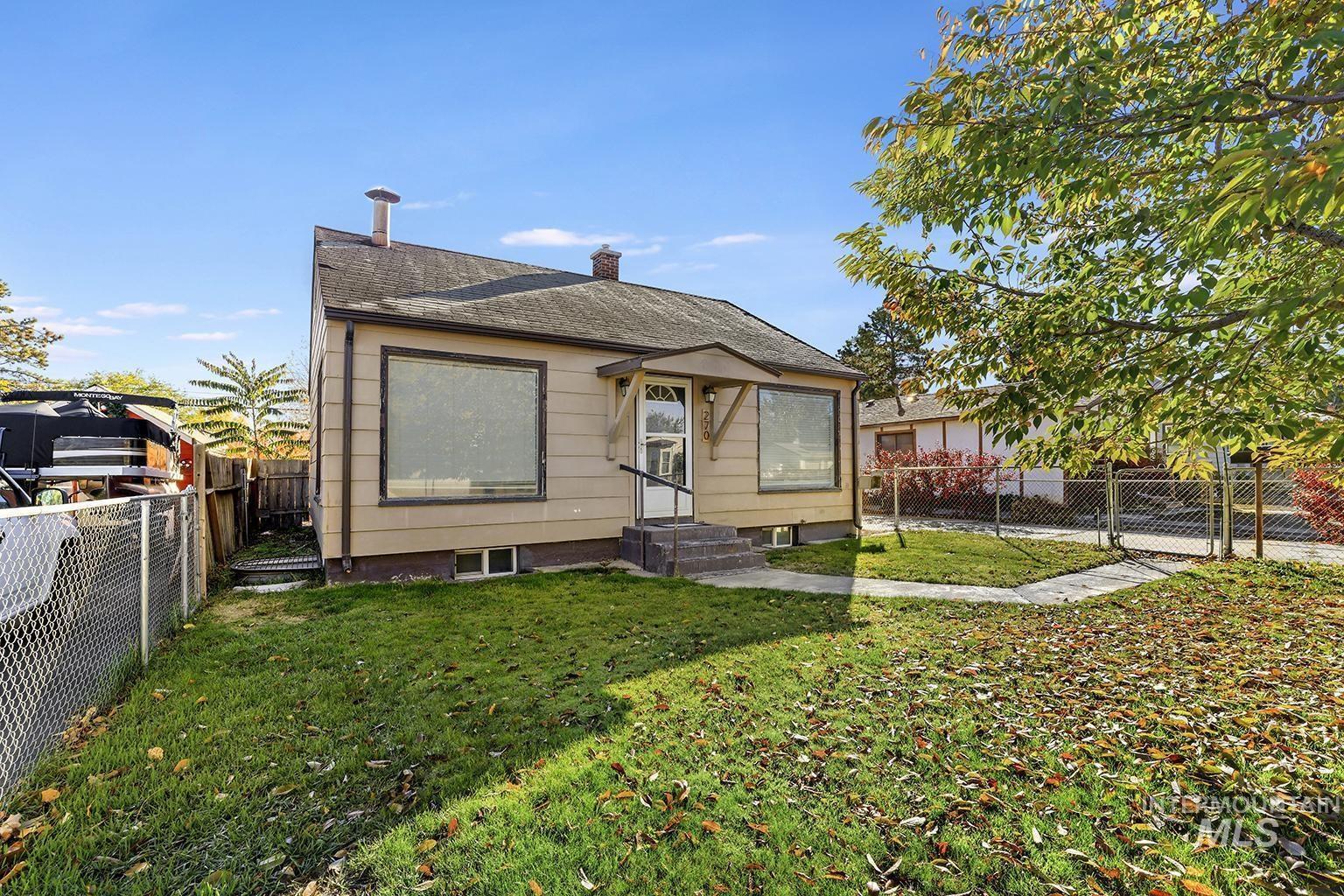 View of front of property with a fenced backyard, a chimney, a shingled roof, and entry steps