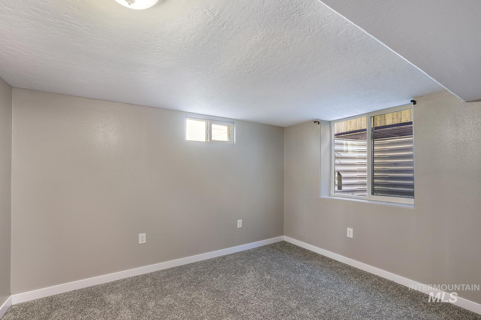 Below grade bedroom with carpet and a textured ceiling