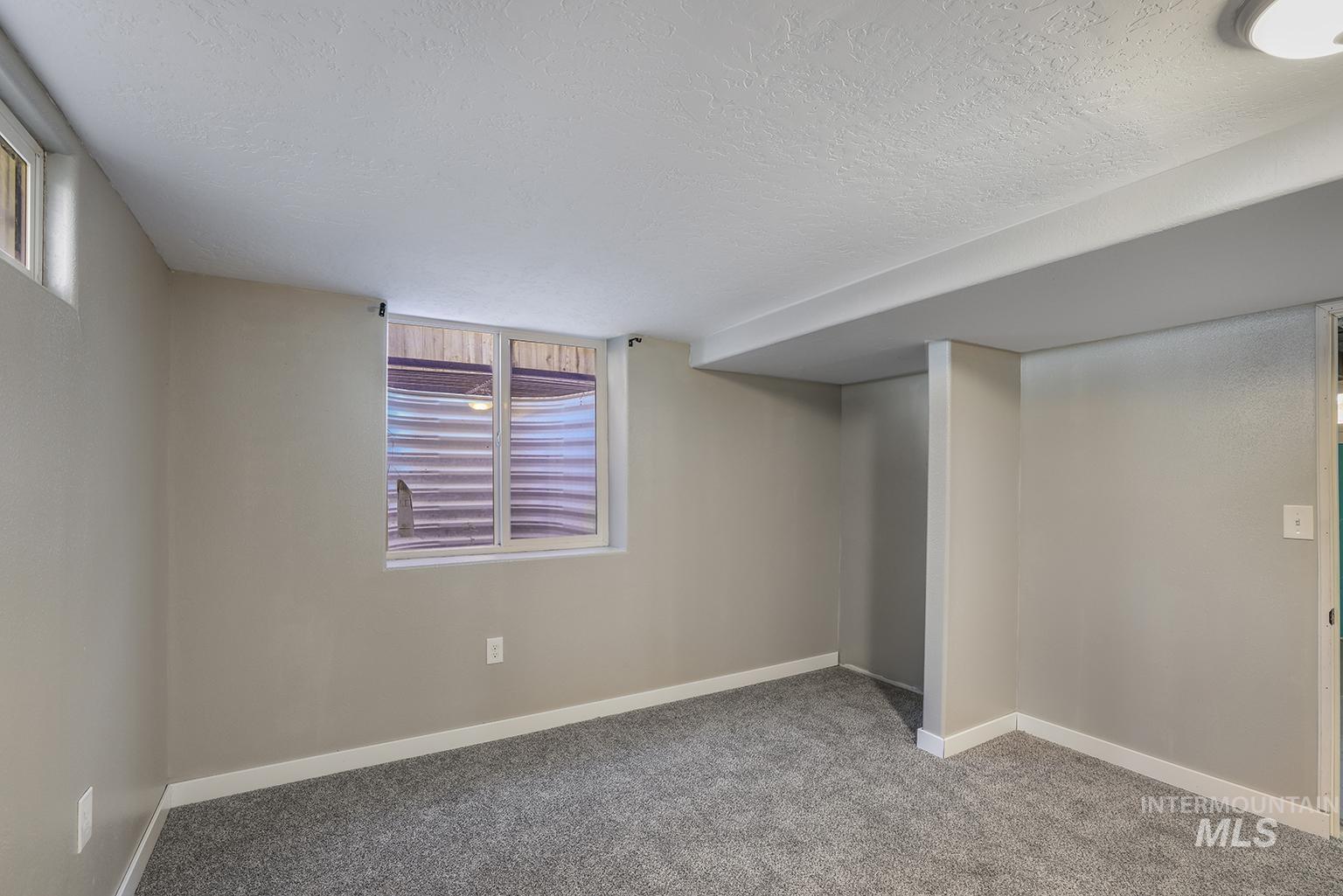 Below grade bedroom featuring carpet flooring and a textured ceiling