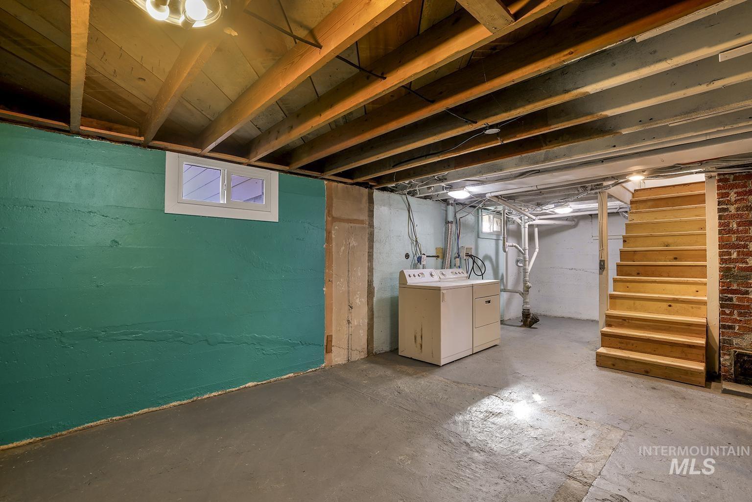 Below grade area featuring stairs and washing machine and clothes dryer