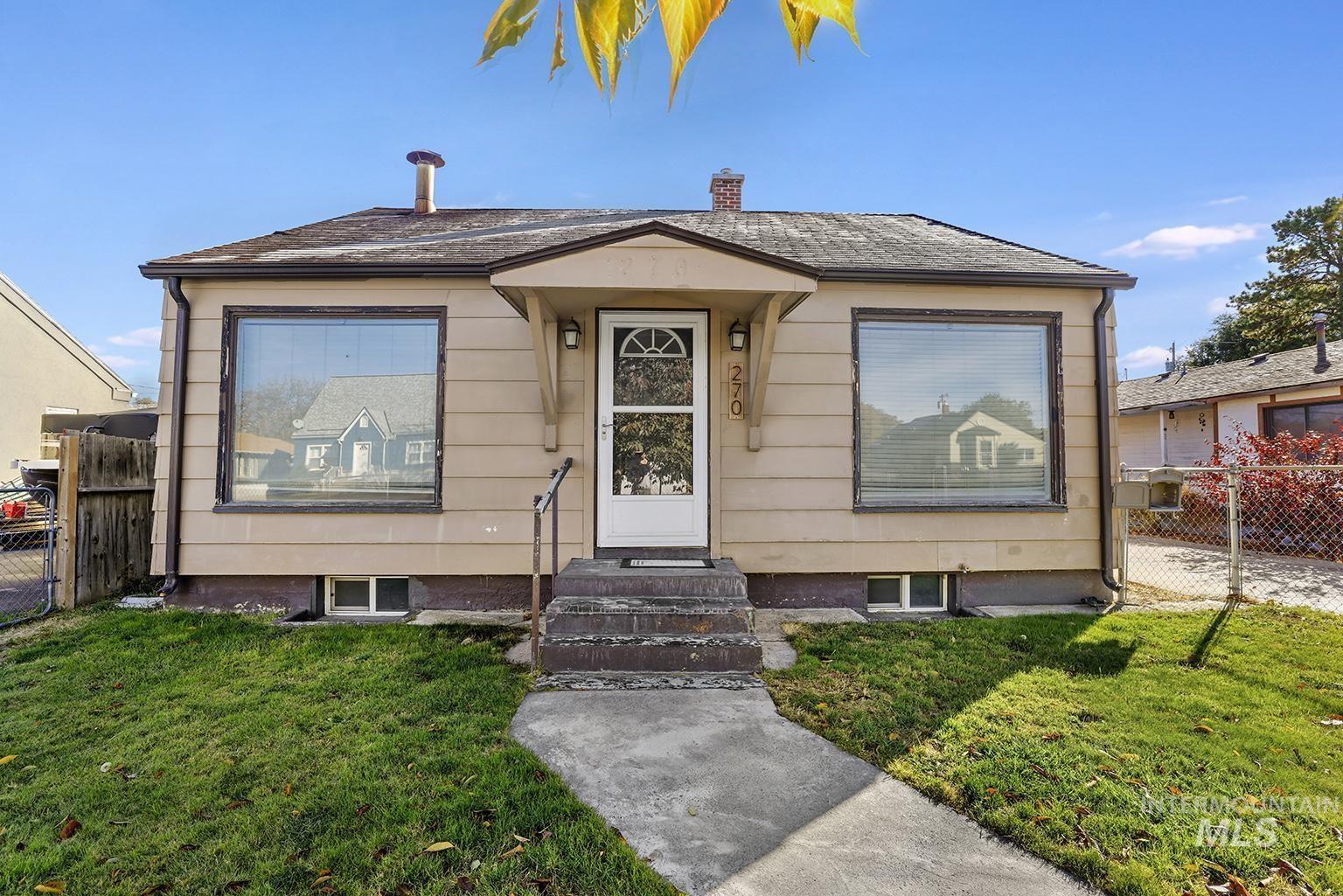 Bungalow-style house with a chimney and a gate