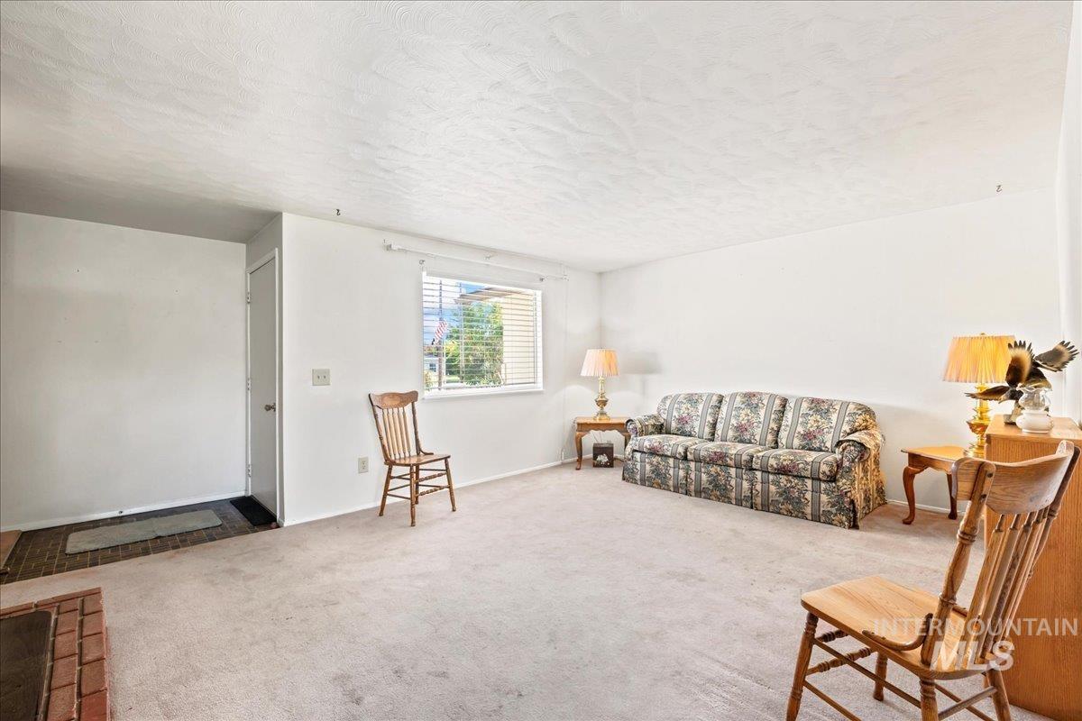 Living room featuring a textured ceiling and carpet floors