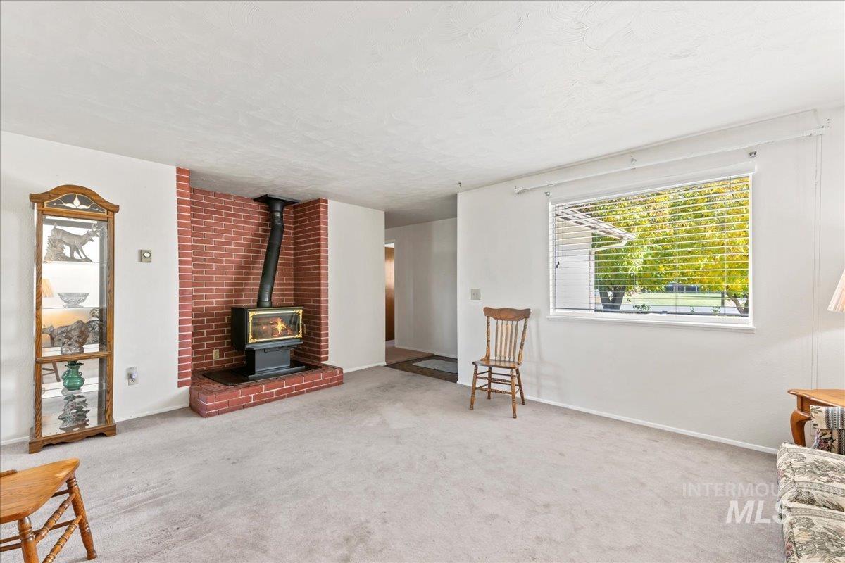 Living area featuring a wood stove and carpet