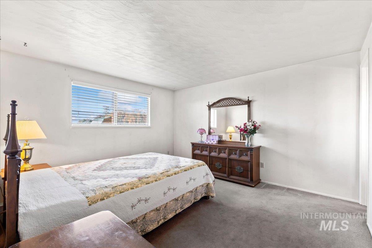 Bedroom featuring carpet and a textured ceiling