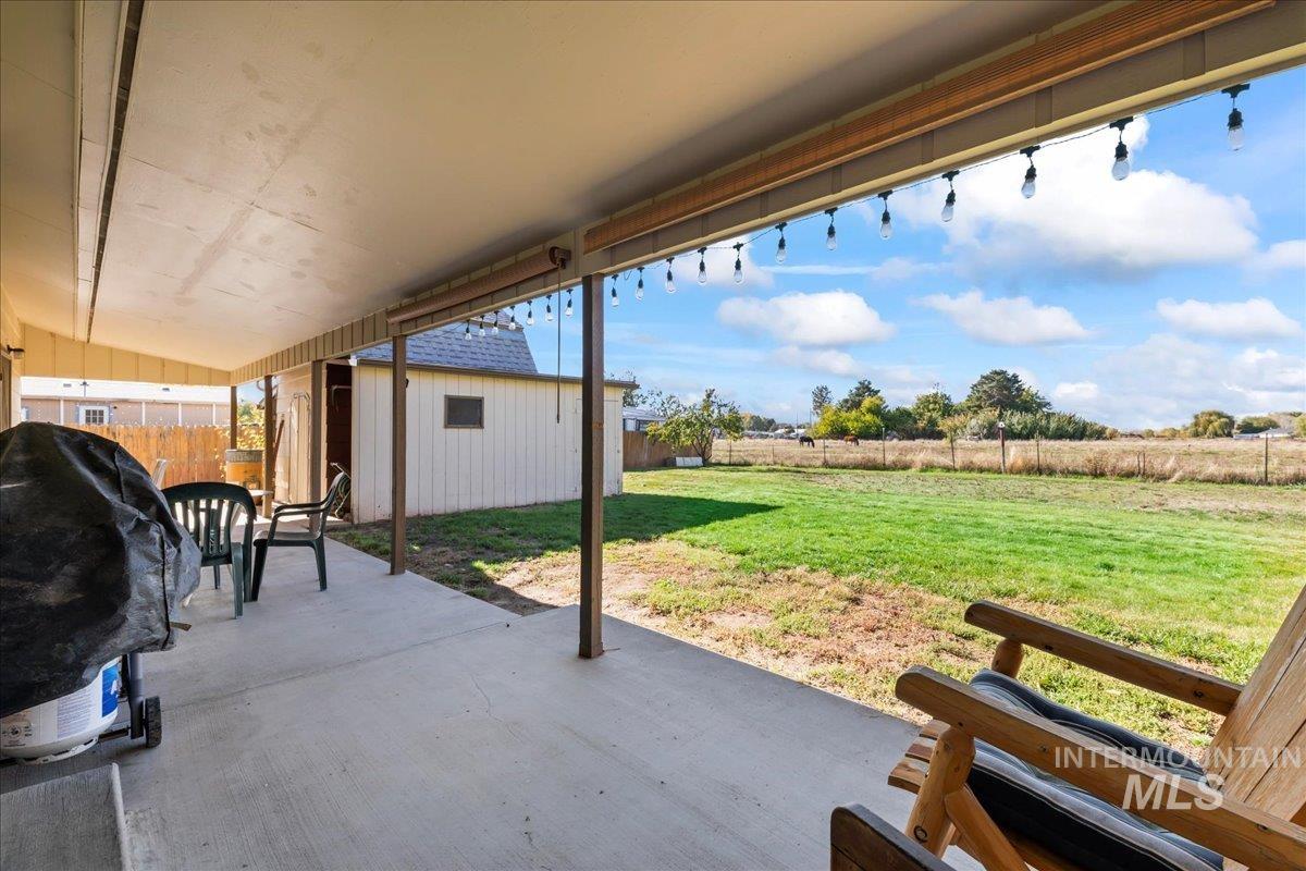 Fenced backyard with a patio and an outbuilding