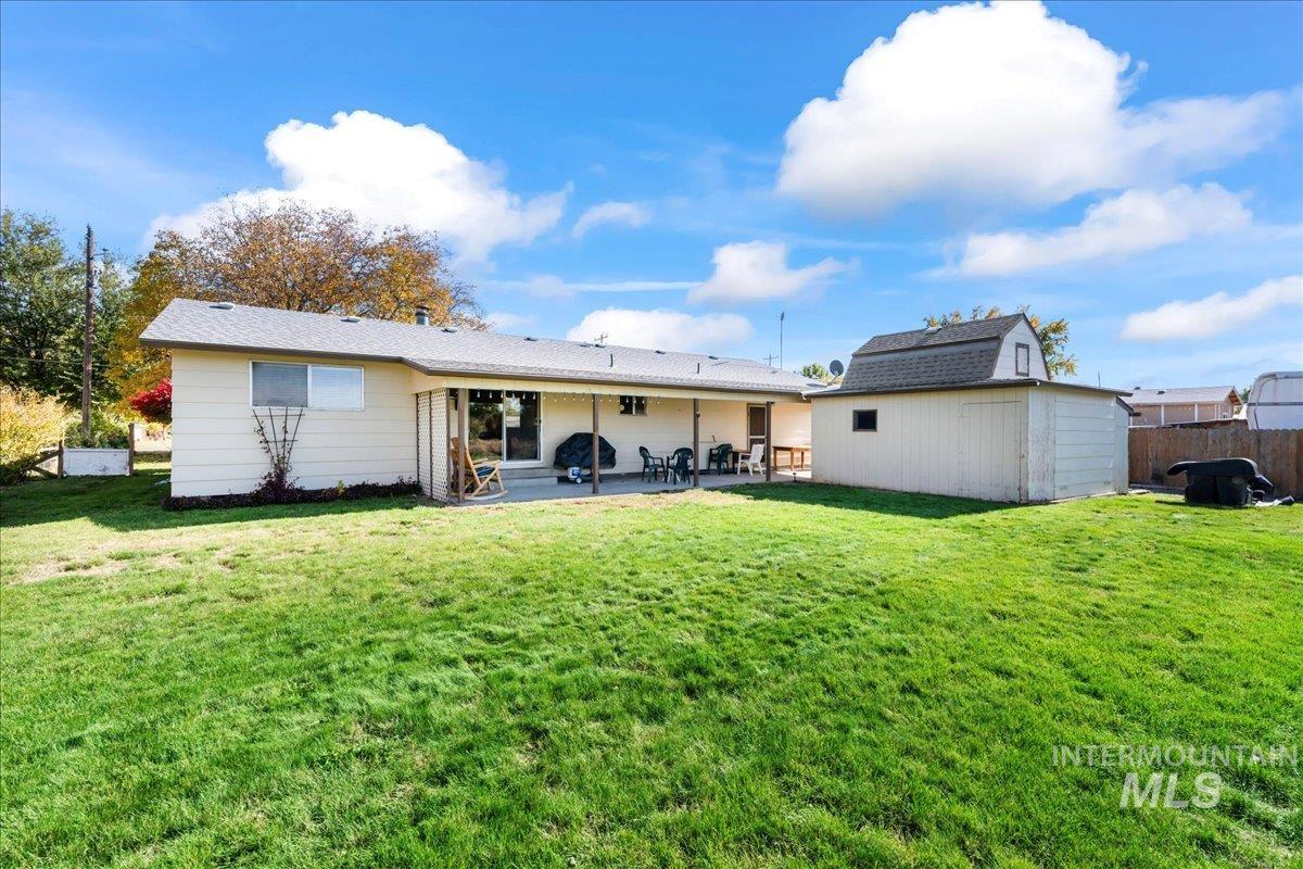 Rear view of property with a patio and a shed
