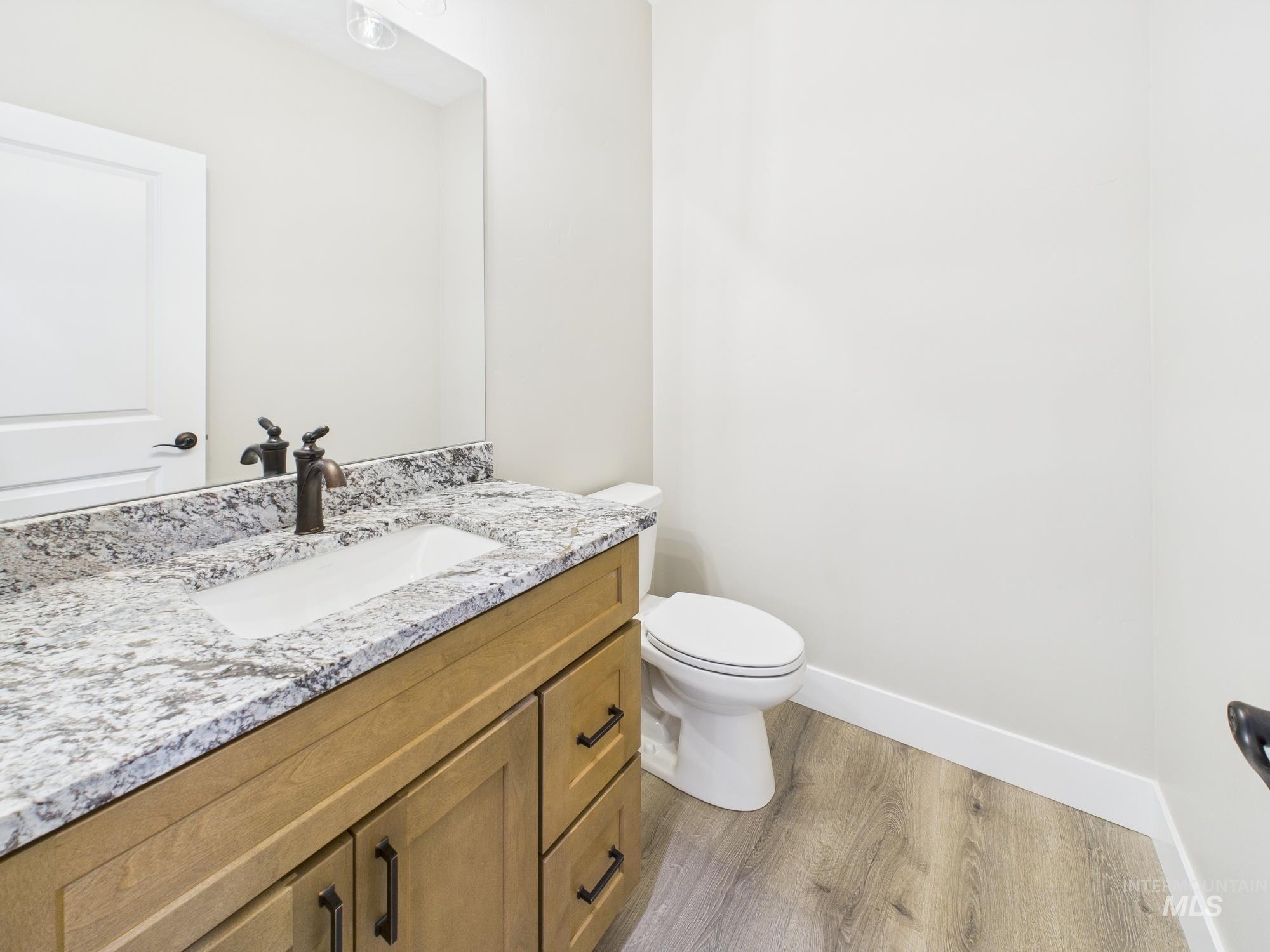 Half bathroom with wood finished floors and vanity