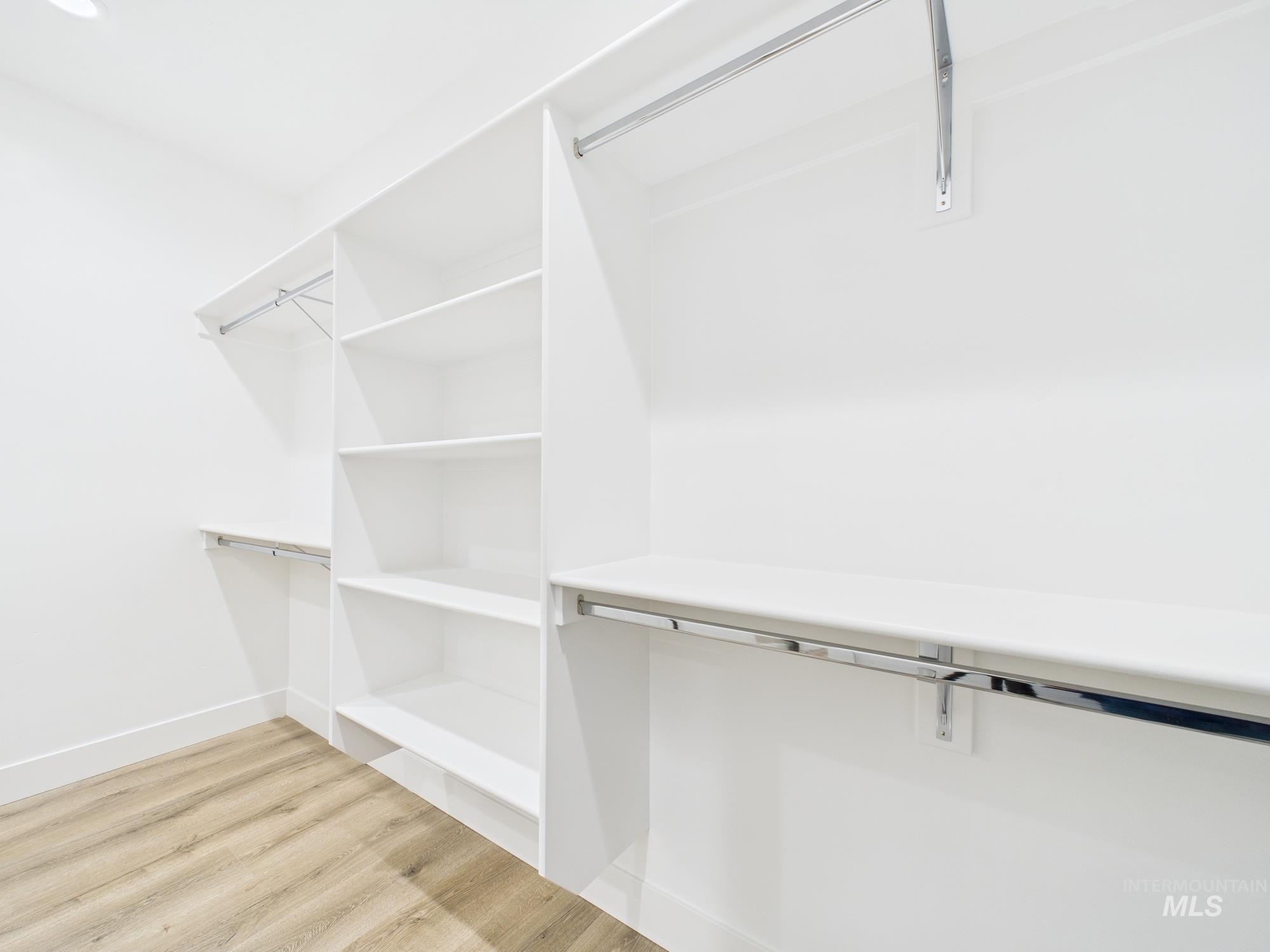 Spacious closet featuring light wood-style flooring
