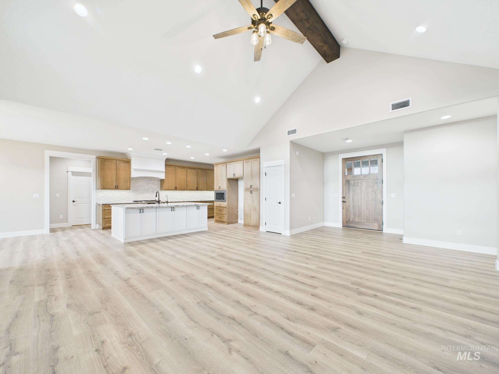 Unfurnished living room with beam ceiling, light wood-type flooring, recessed lighting, high vaulted ceiling, and a ceiling fan