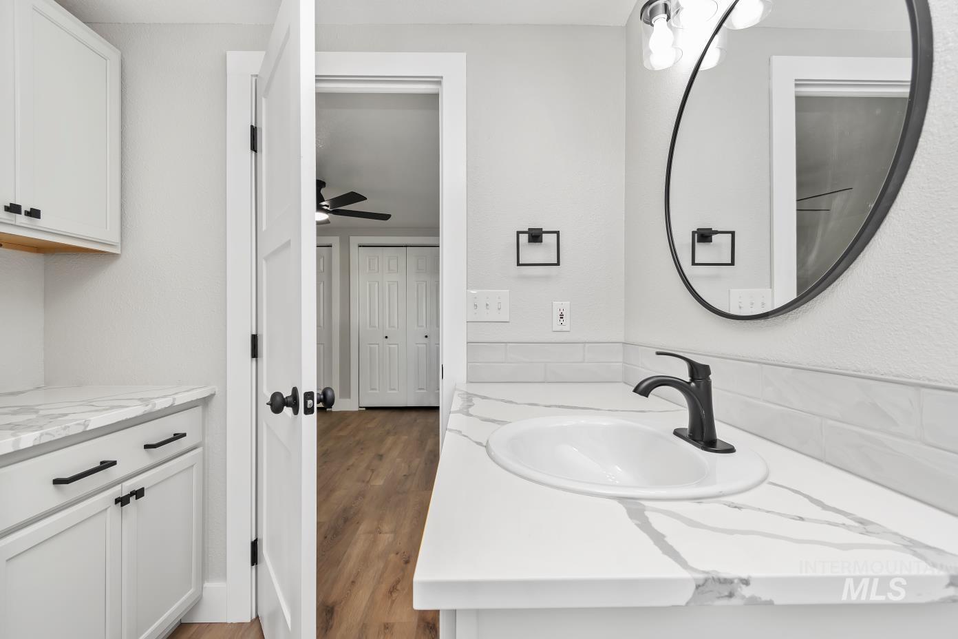 Bathroom featuring light wood-type flooring, vanity, and a ceiling fan