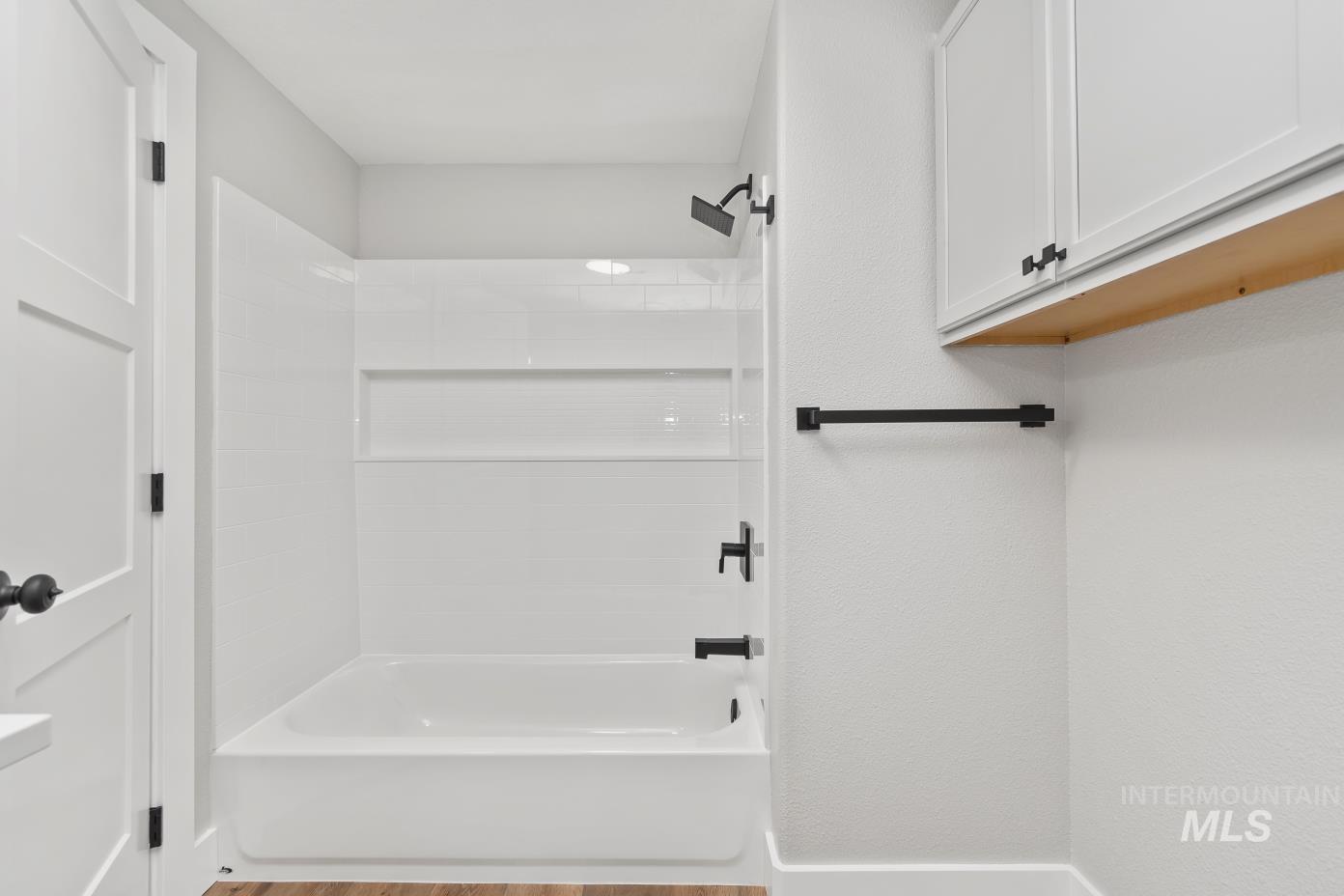 Full bathroom with light wood-type flooring and shower / tub combination