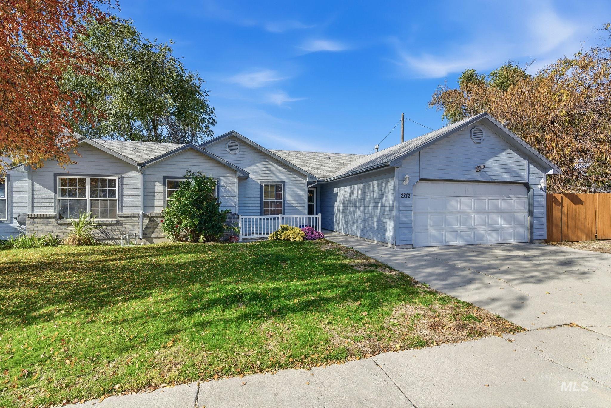 Ranch-style home featuring a front yard, driveway, and an attached garage