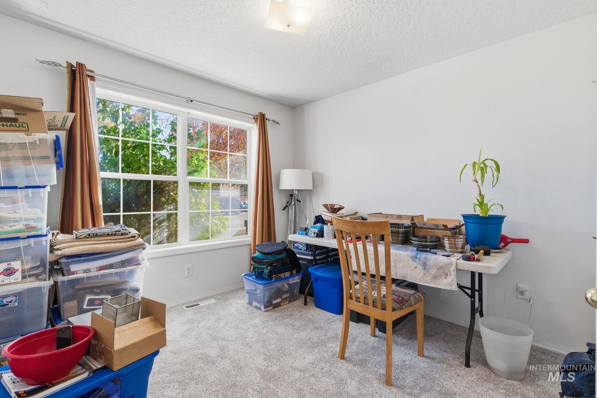 Home office featuring light carpet and a textured ceiling