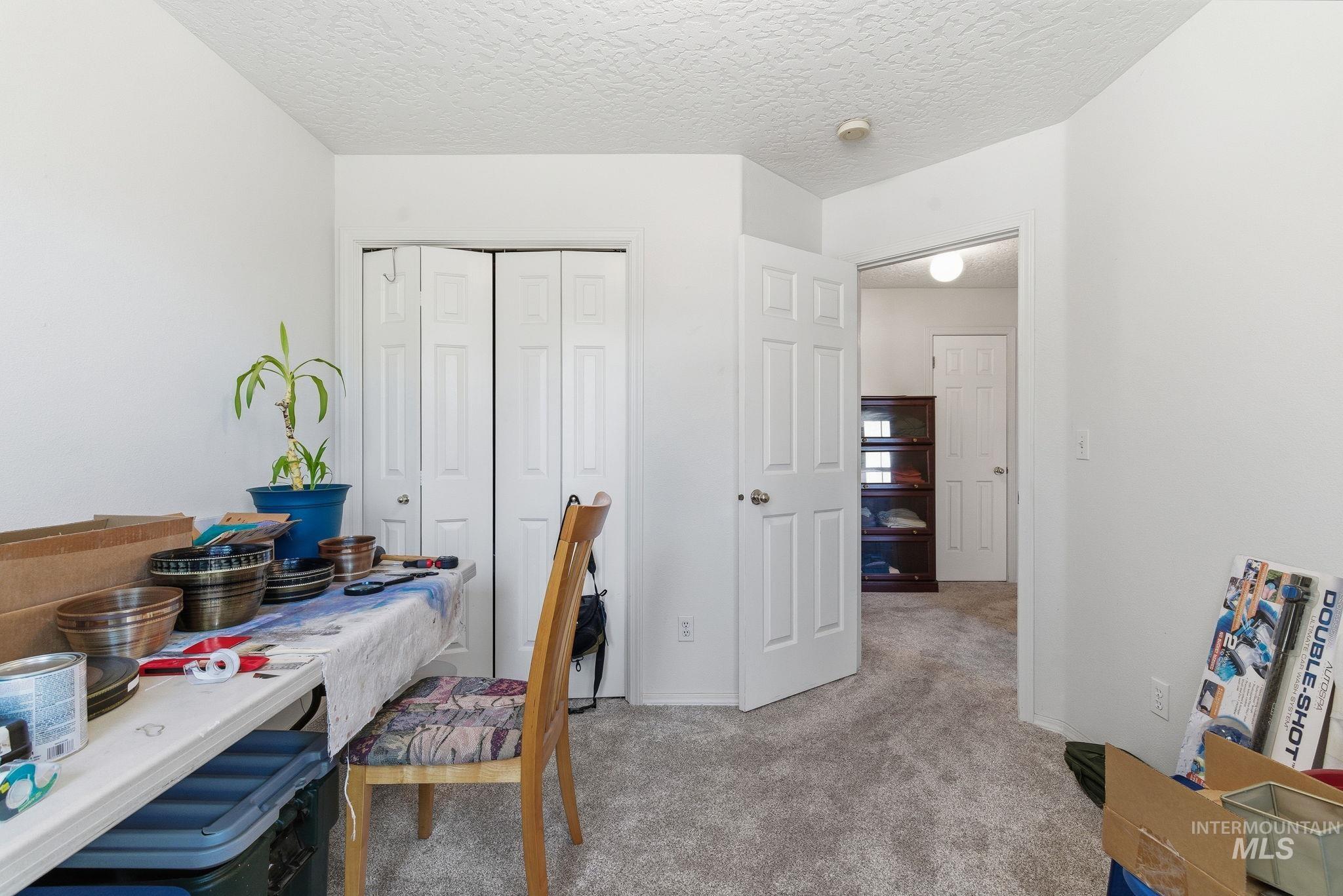 Office with light carpet and a textured ceiling