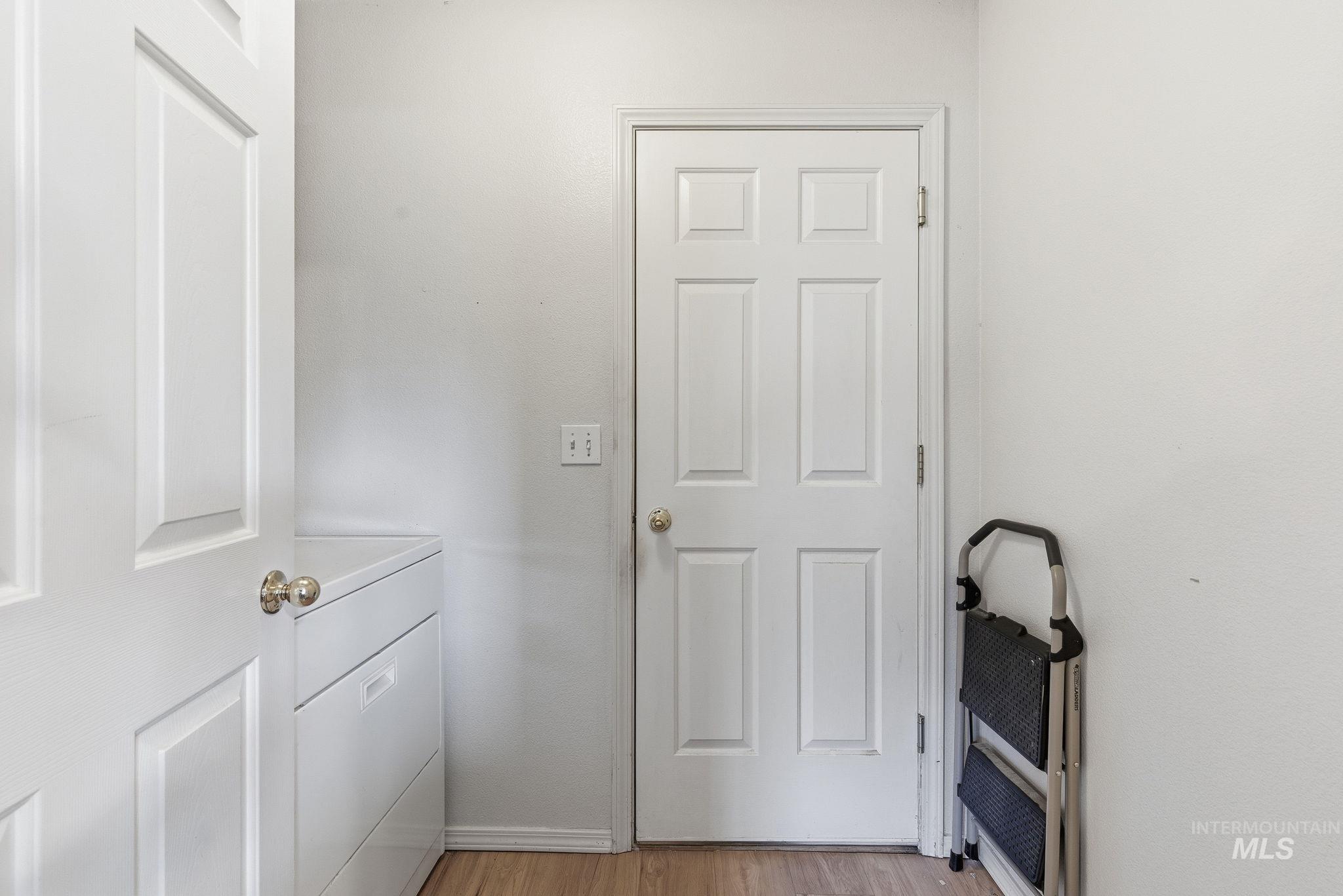 Doorway featuring wood finished floors and washer / dryer