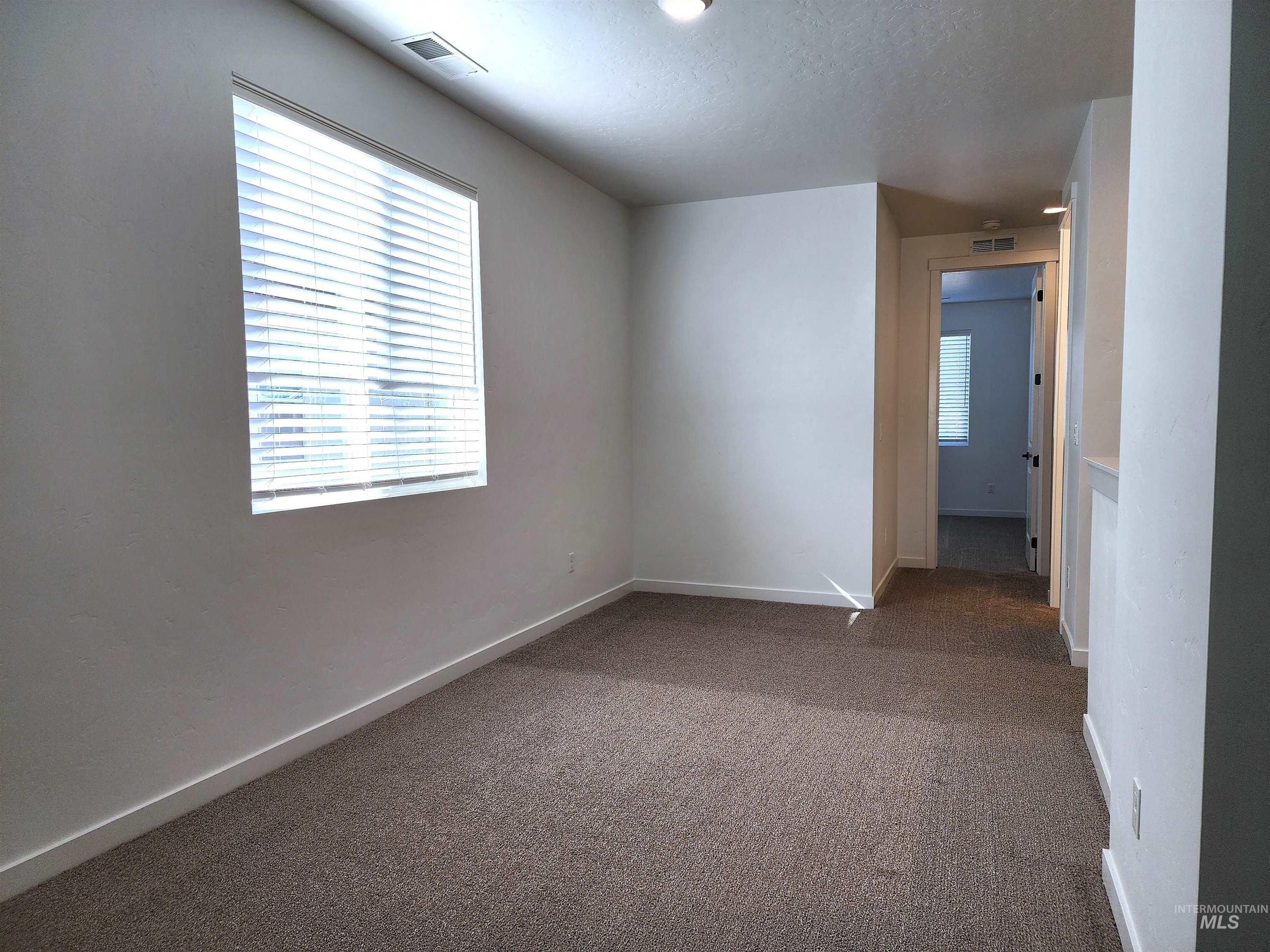 Unfurnished room with carpet floors and a textured ceiling