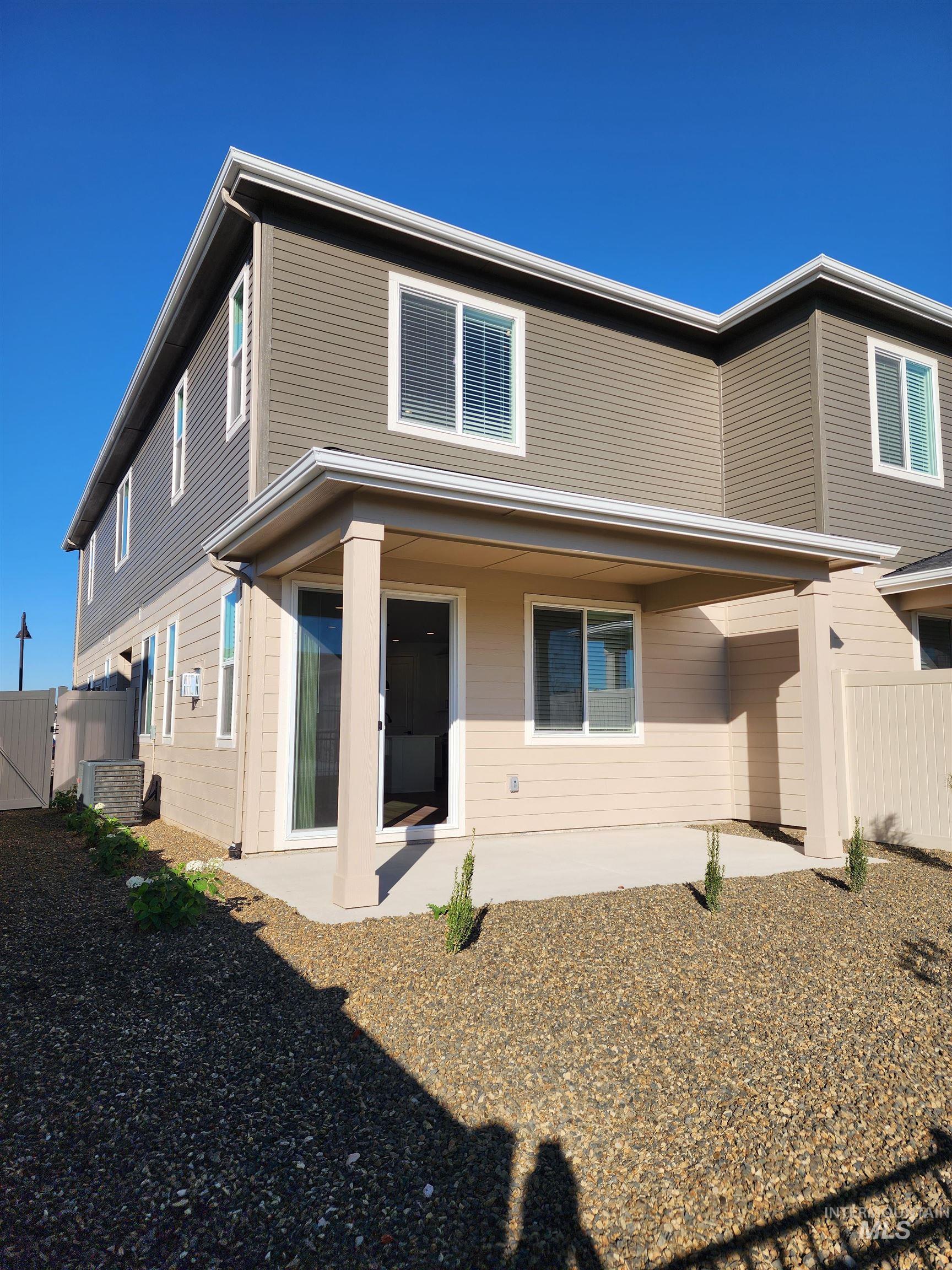 Rear view of house with a patio area and a gate