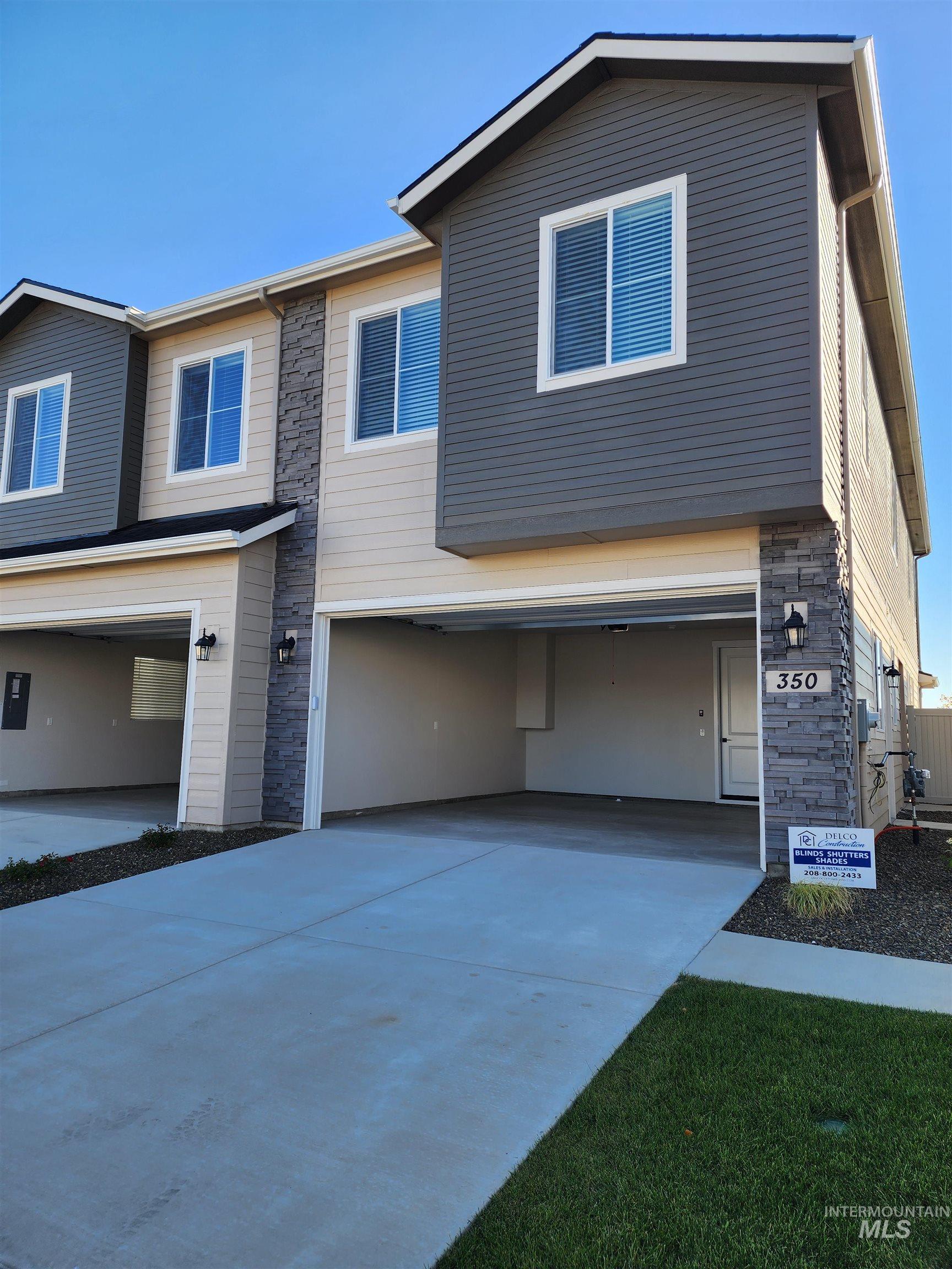 View of front of house featuring stone siding and driveway