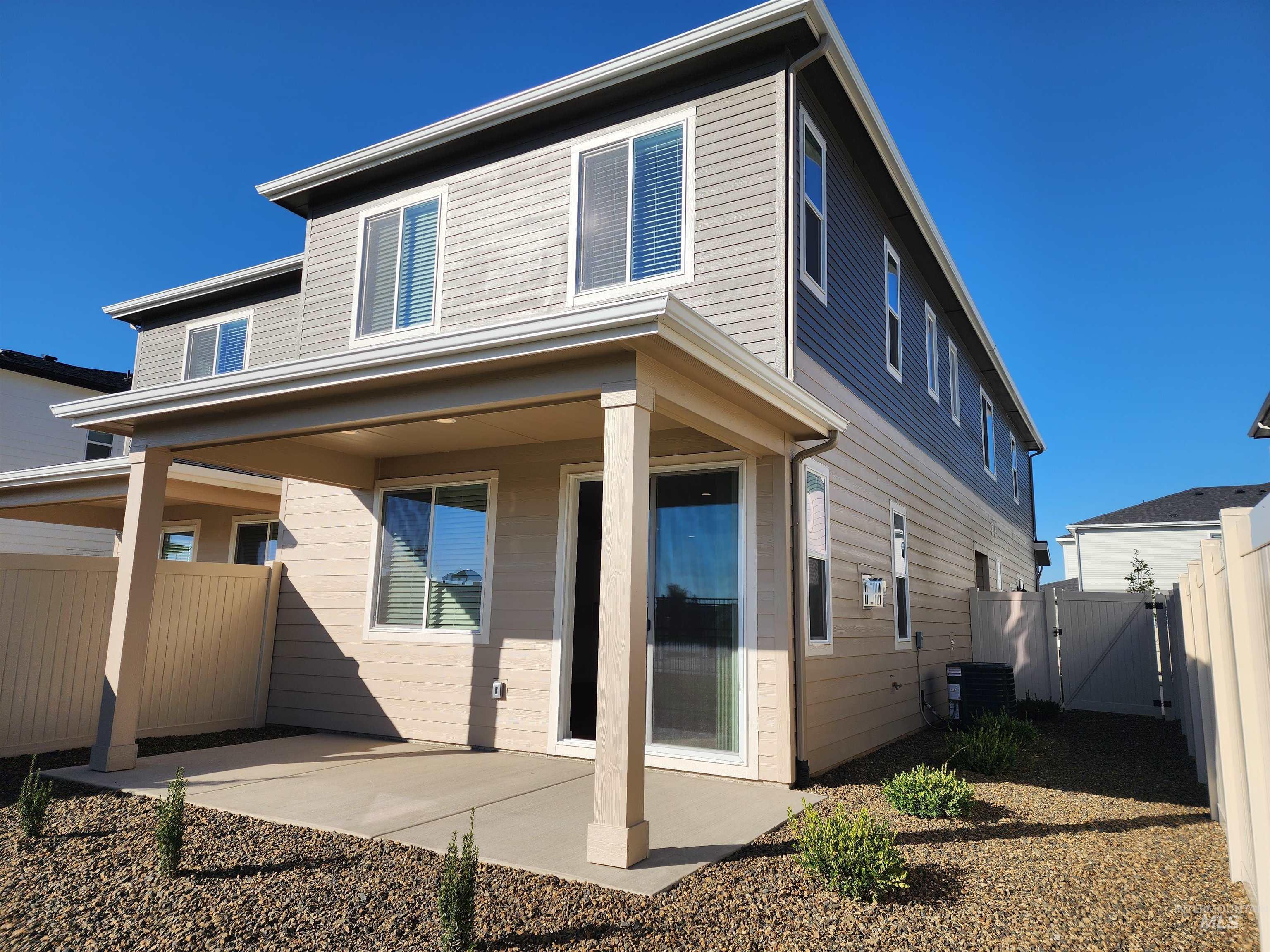 Rear view of property featuring a fenced backyard, a patio, and a gate