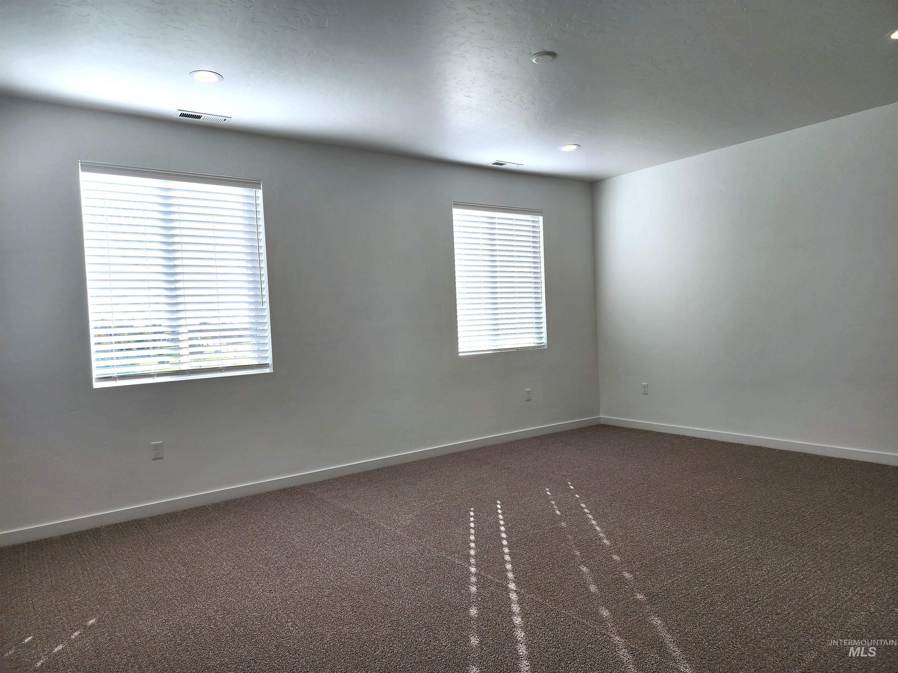 Unfurnished room featuring dark carpet and recessed lighting