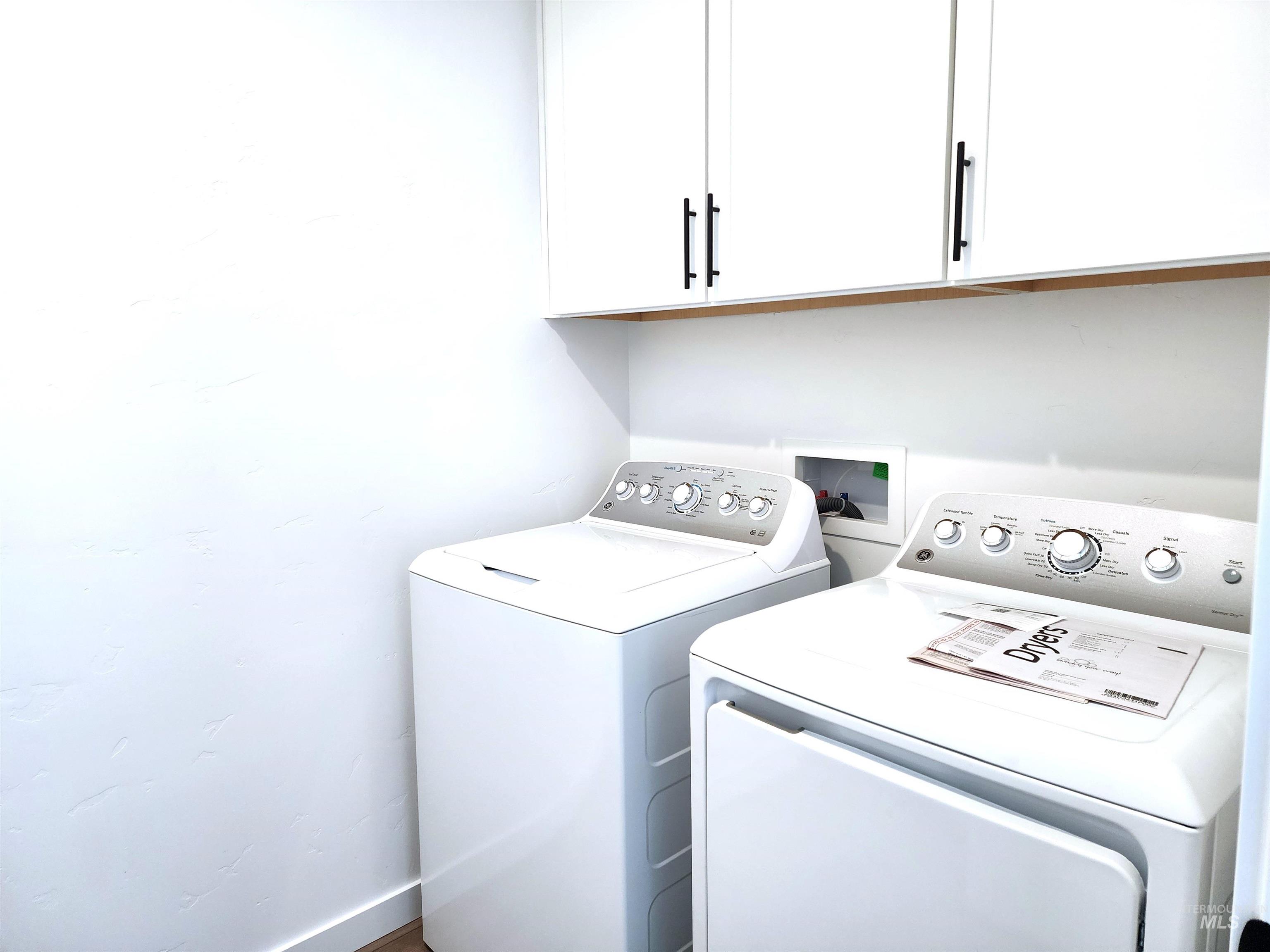 Laundry area featuring cabinet space and washer and clothes dryer