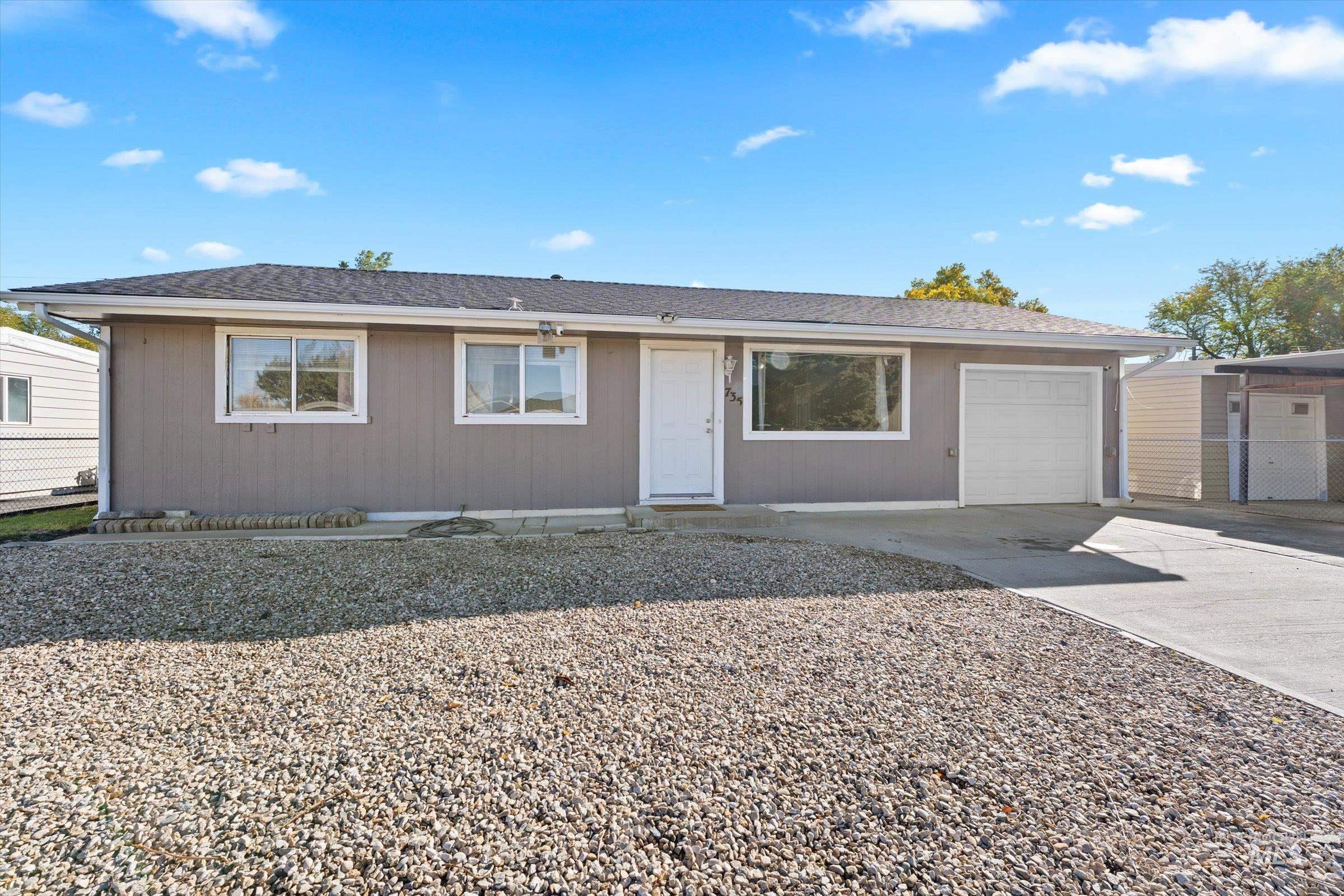 Single story home featuring concrete driveway, roof with shingles, and an attached garage