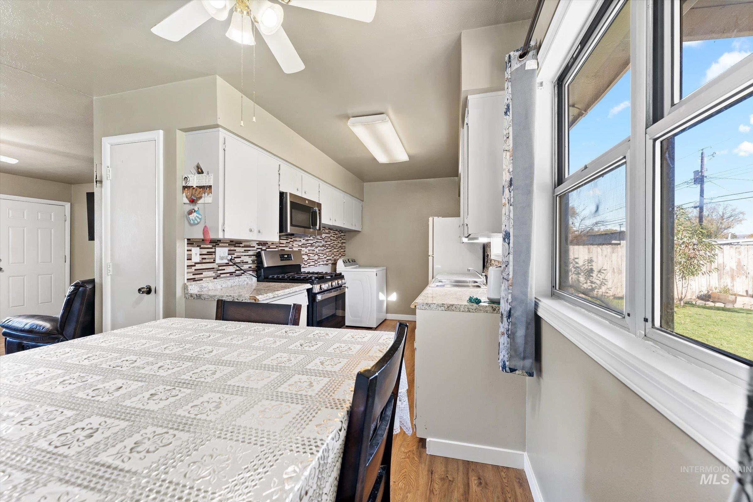 Bedroom with washer / clothes dryer, dark wood-type flooring, freestanding refrigerator, and ceiling fan