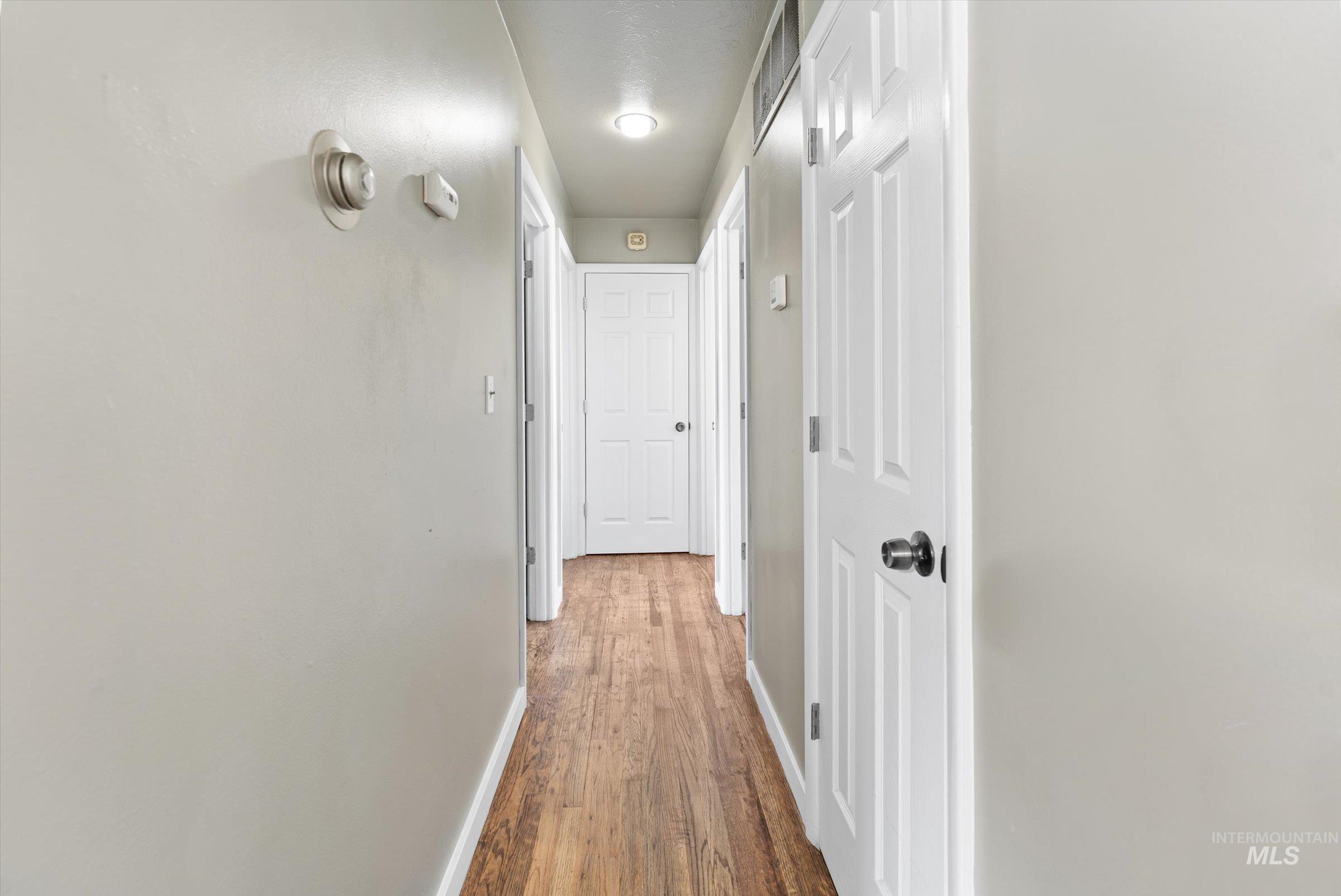 Corridor with baseboards and wood finished floors