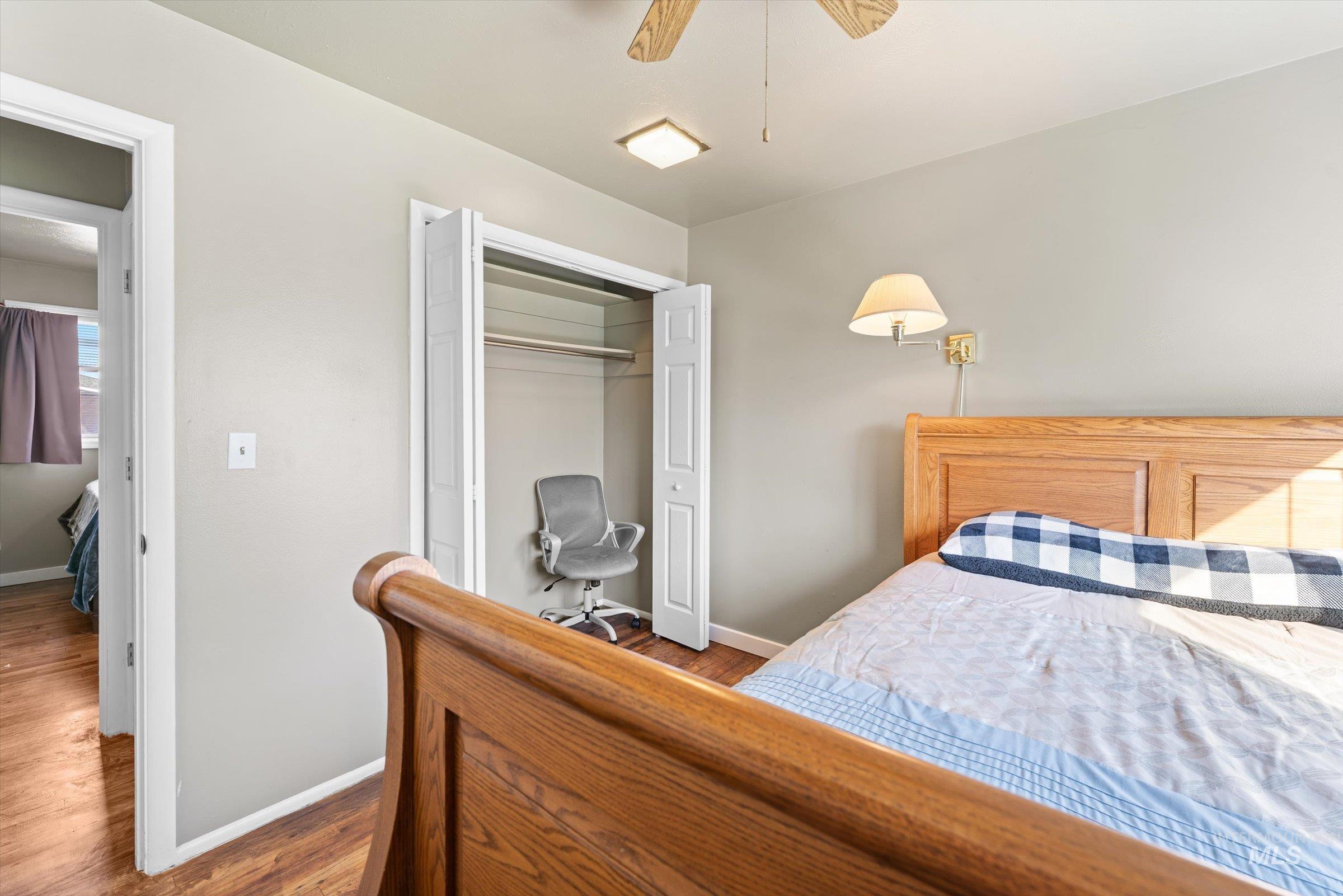 Bedroom featuring wood finished floors, a closet, and a ceiling fan