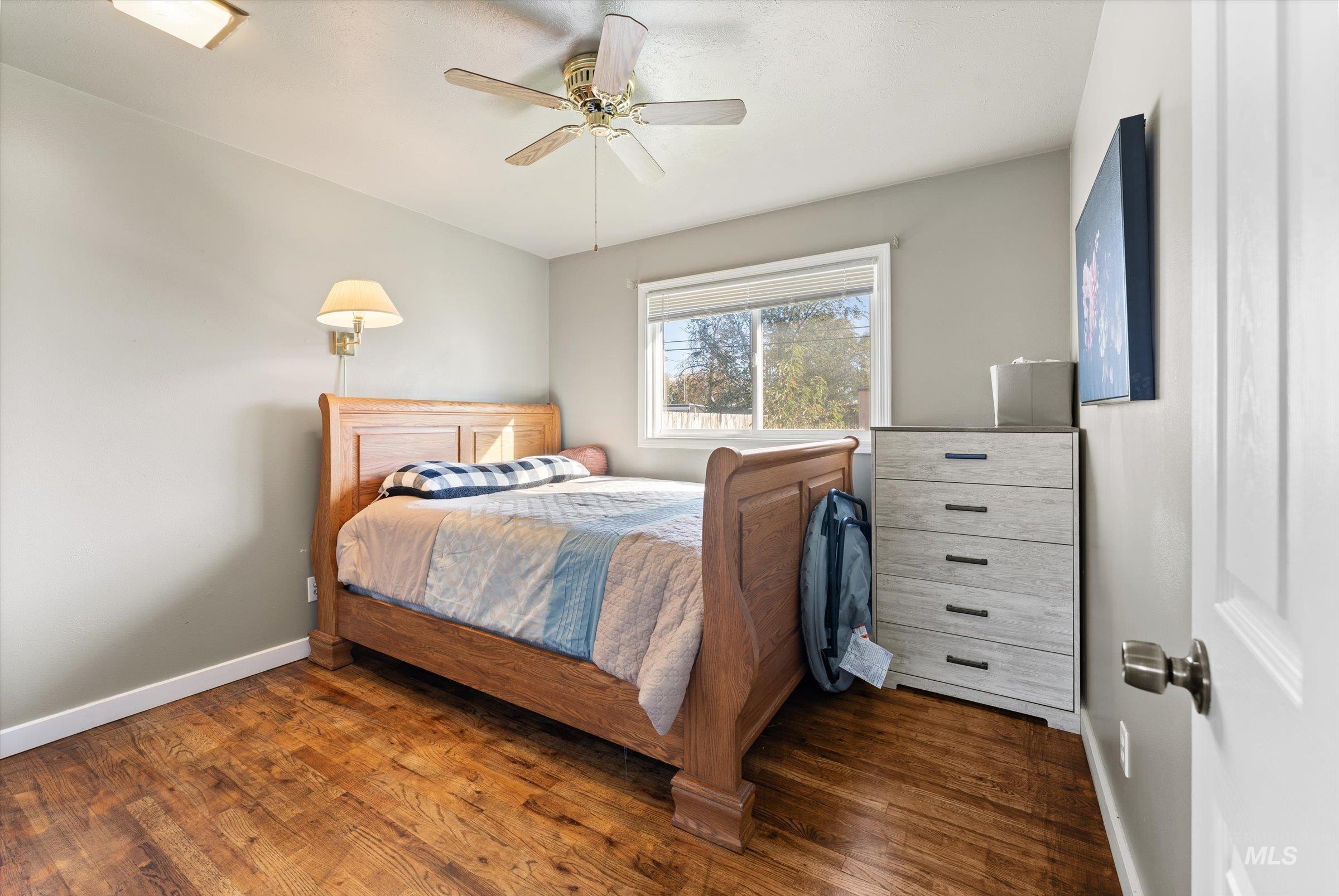 Bedroom with dark wood finished floors and ceiling fan