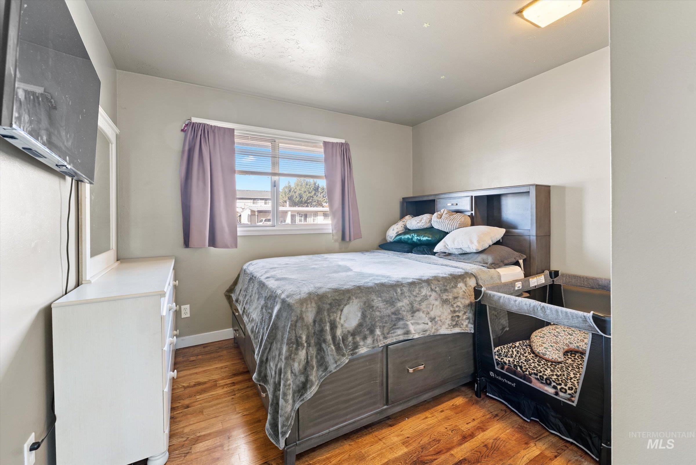 Bedroom featuring wood finished floors and baseboards