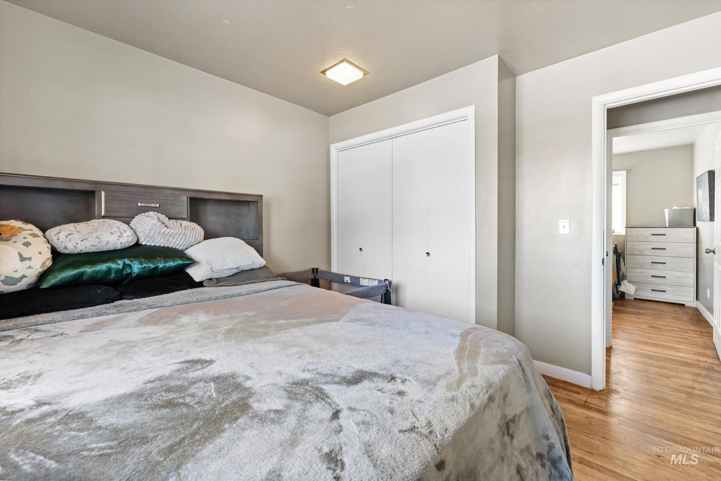 Bedroom with wood finished floors and a closet