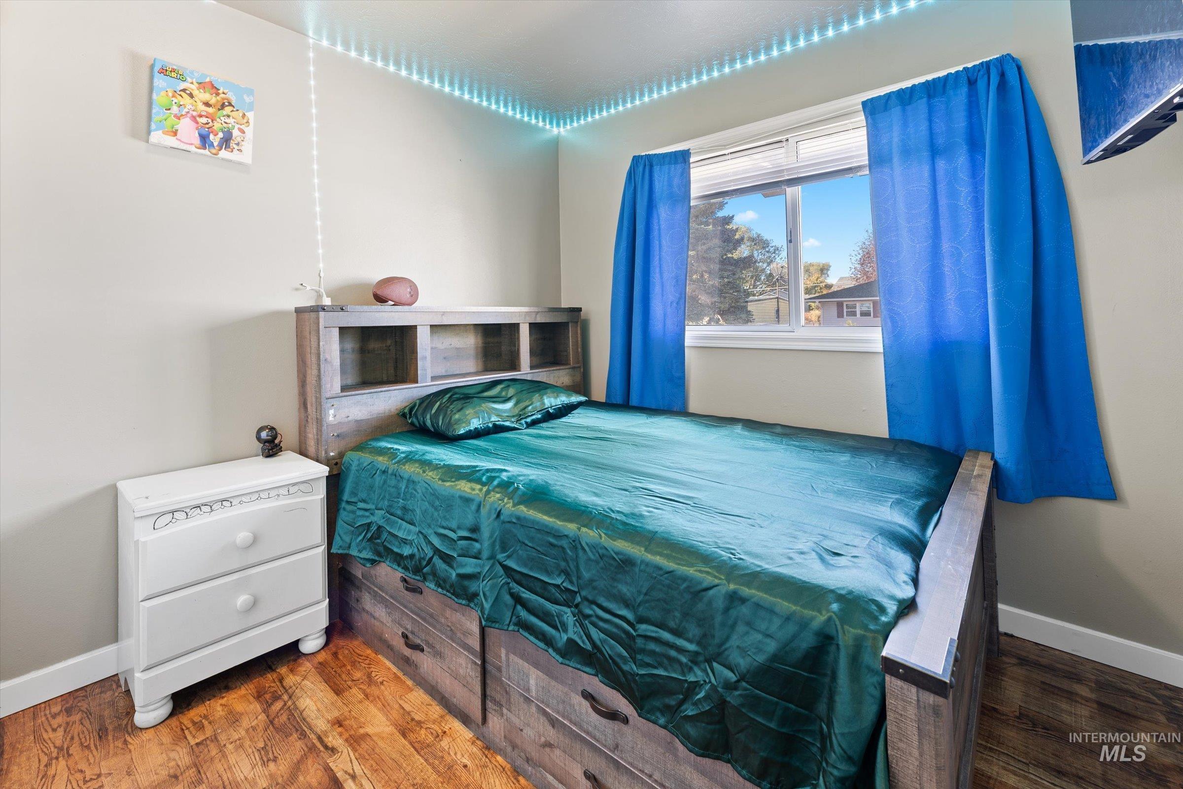 Bedroom with baseboards and wood finished floors