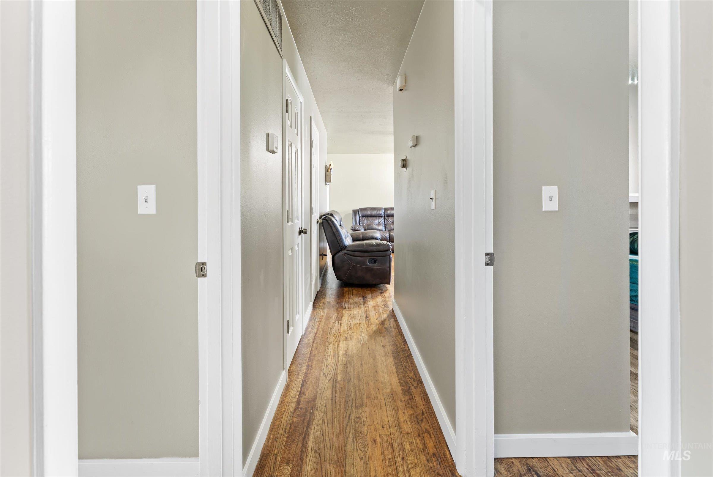 Corridor featuring dark wood finished floors and baseboards