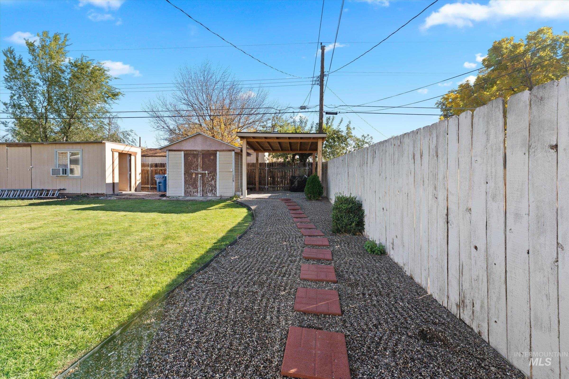 Fenced backyard featuring a storage shed