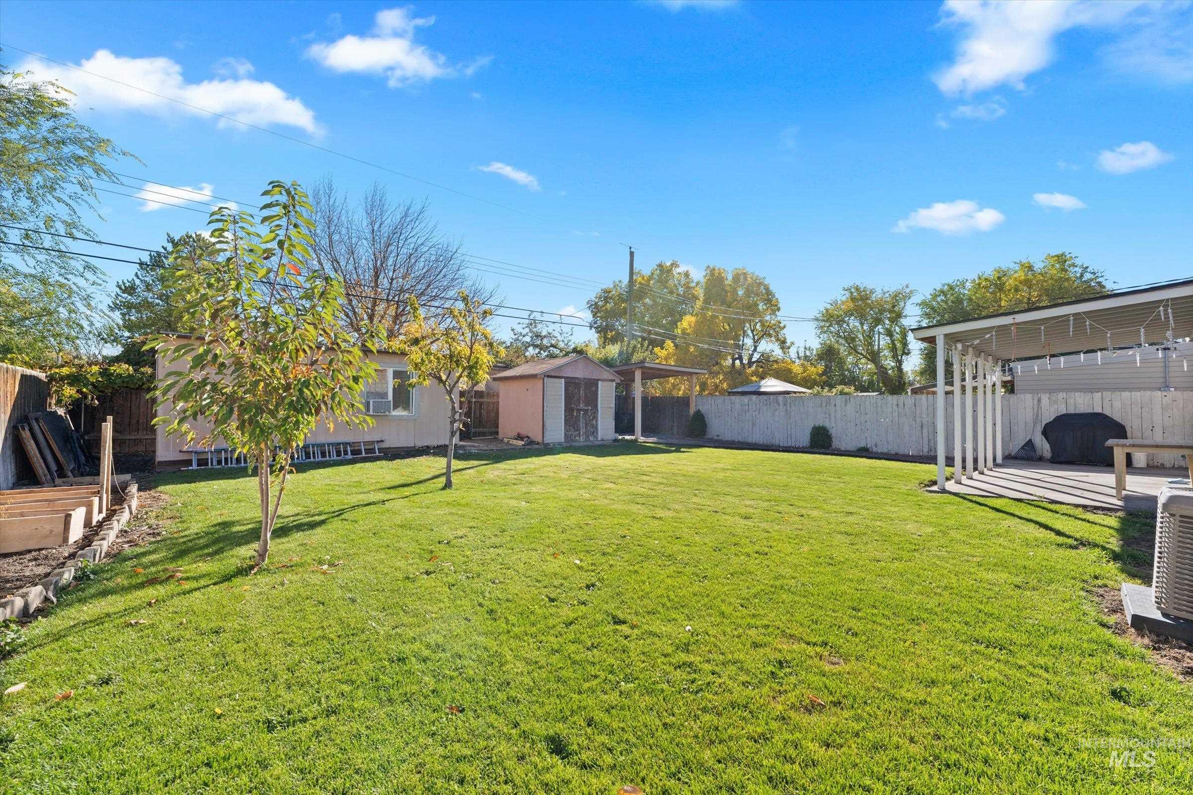 Fenced backyard featuring a shed and a patio