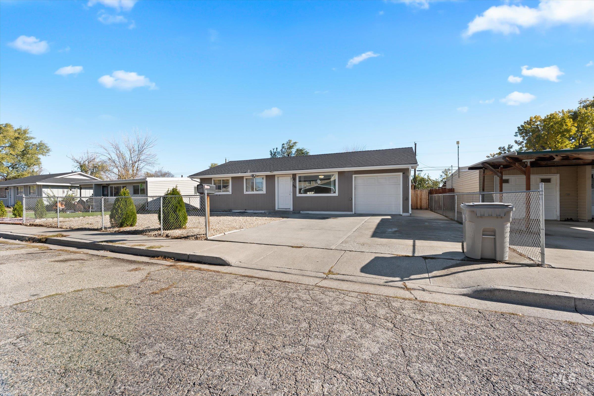 View of front of house with driveway and a gate